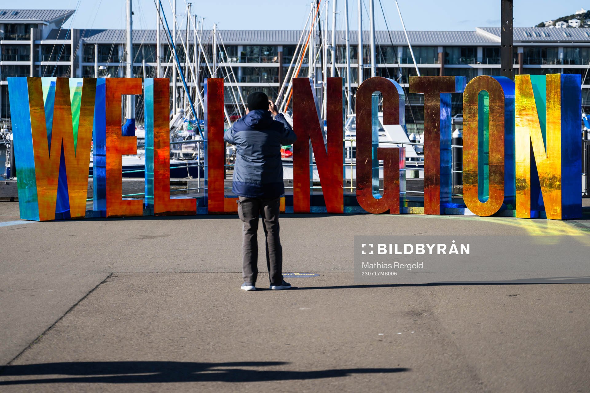A man photographs letters spelling ”Wellington”