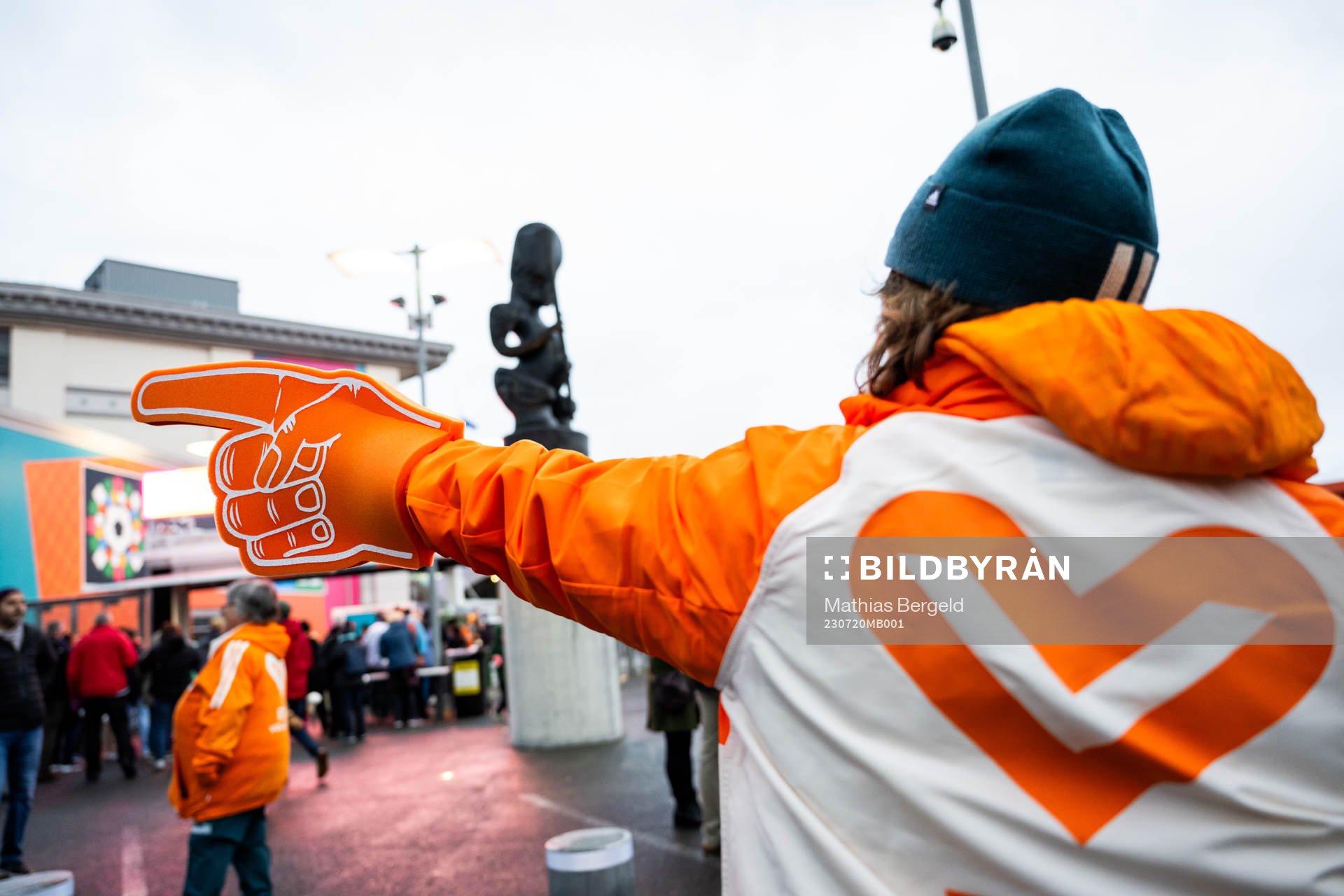 A volunteer points directions for spectators outside the