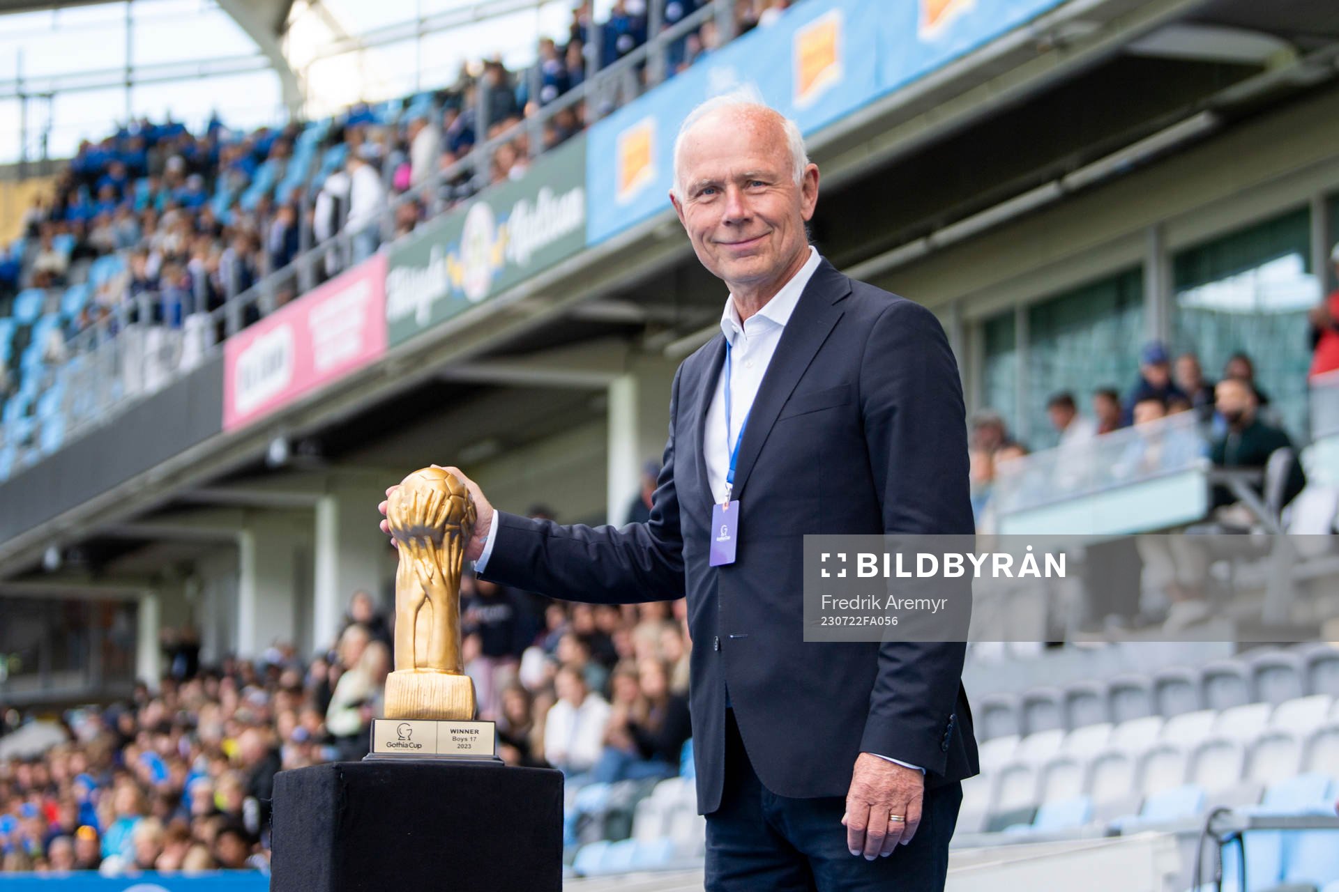 Prisutdelare Dennis Andersson poserar med en pokal