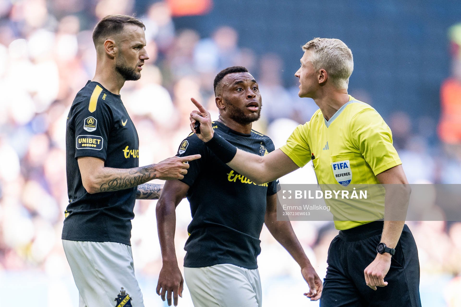 AIKs Alexander Milosevic och Abdussalam Magashy i diskussion med Domare Adam Ladebäck under fotbollsmatchen i Allsvenskan mellan AIK och Malmö FF den 23 juli 2023 i Stockholm.