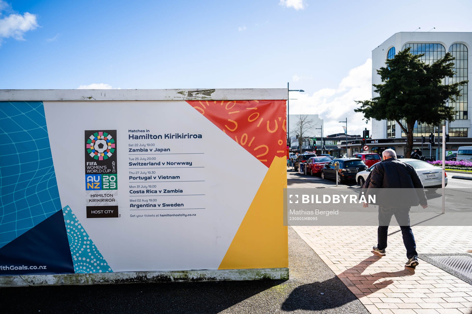 A man walks past barriers with the logo for the FIFA