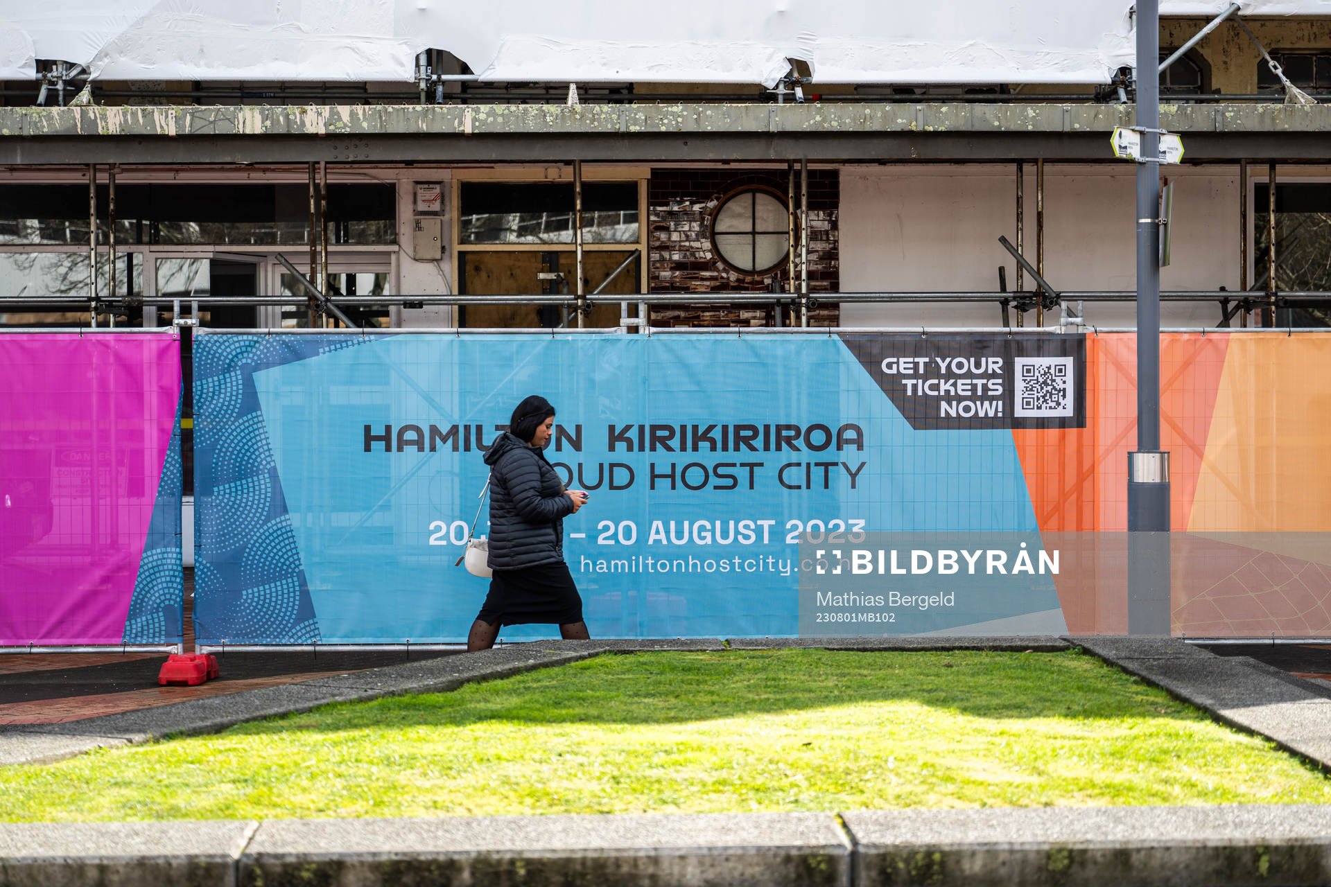 A woman walks past barriers