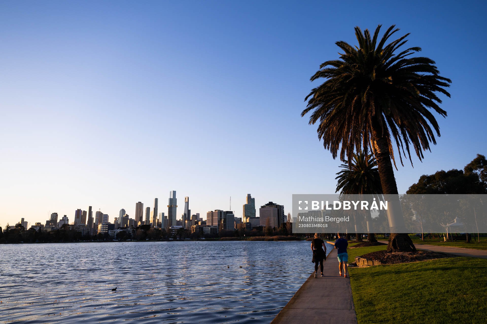 The citys skyline as seen from Albert Park where two people