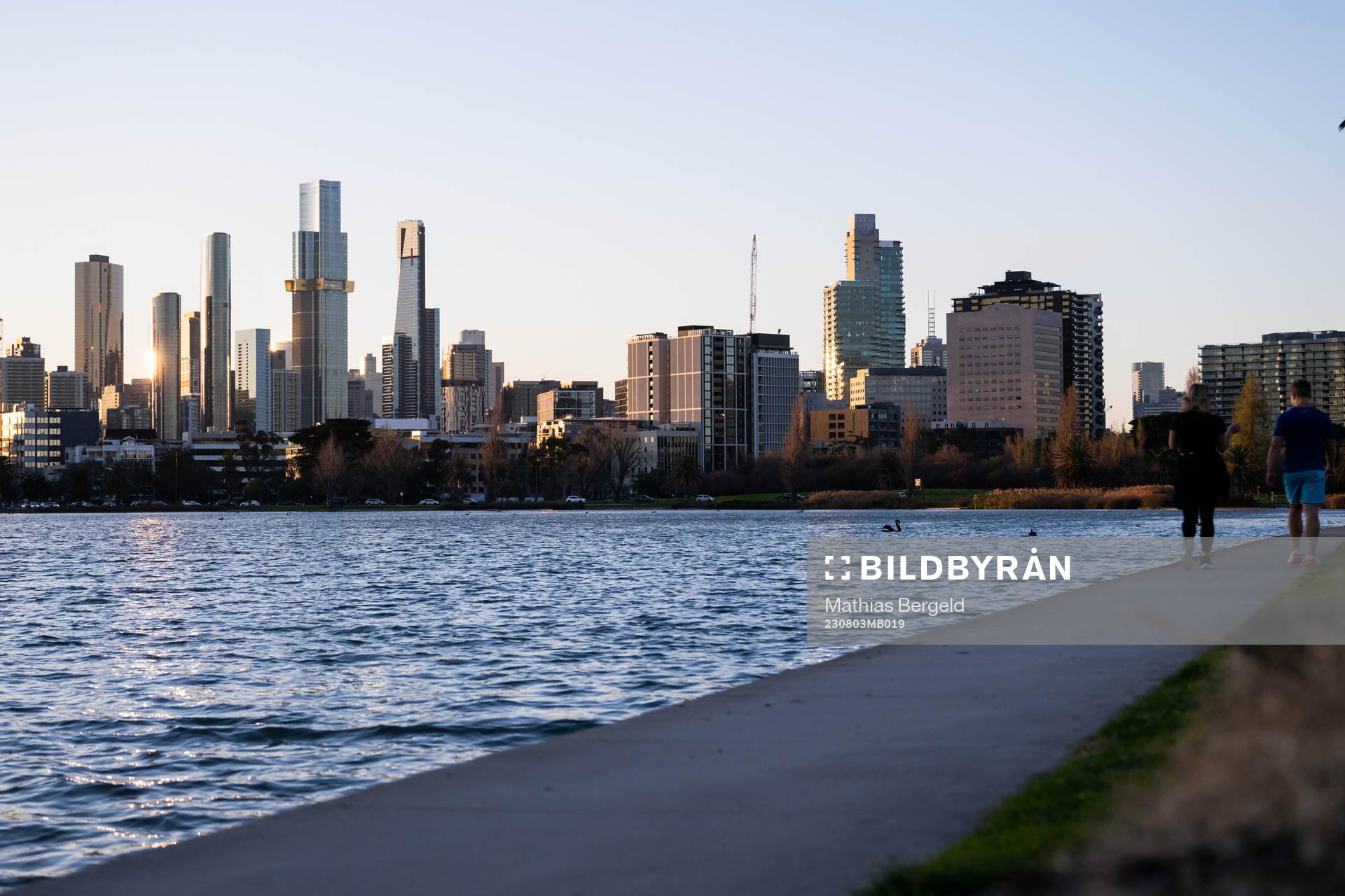 The citys skyline as seen from Albert Park where two people