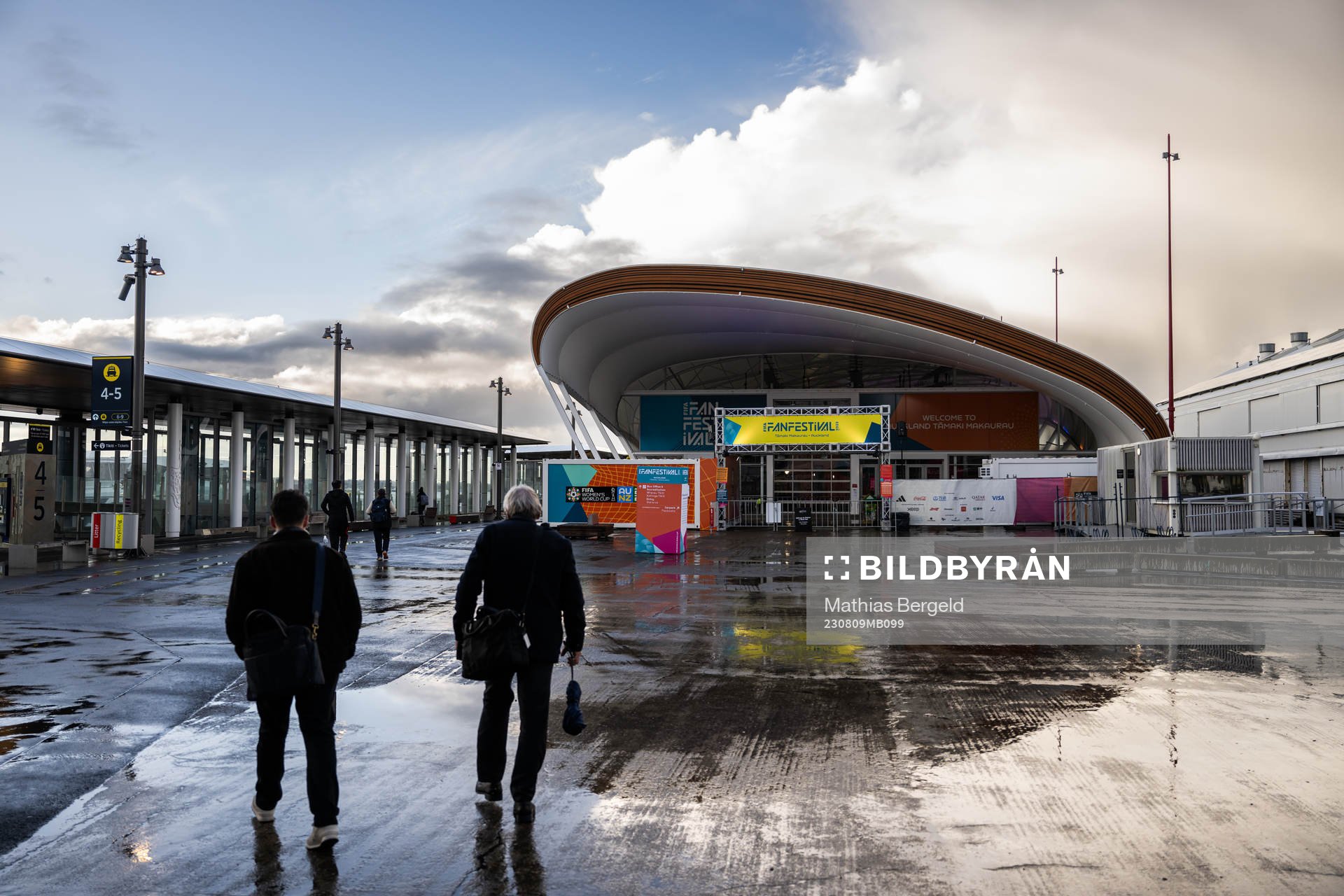People walk past the FIFA Fan Zone