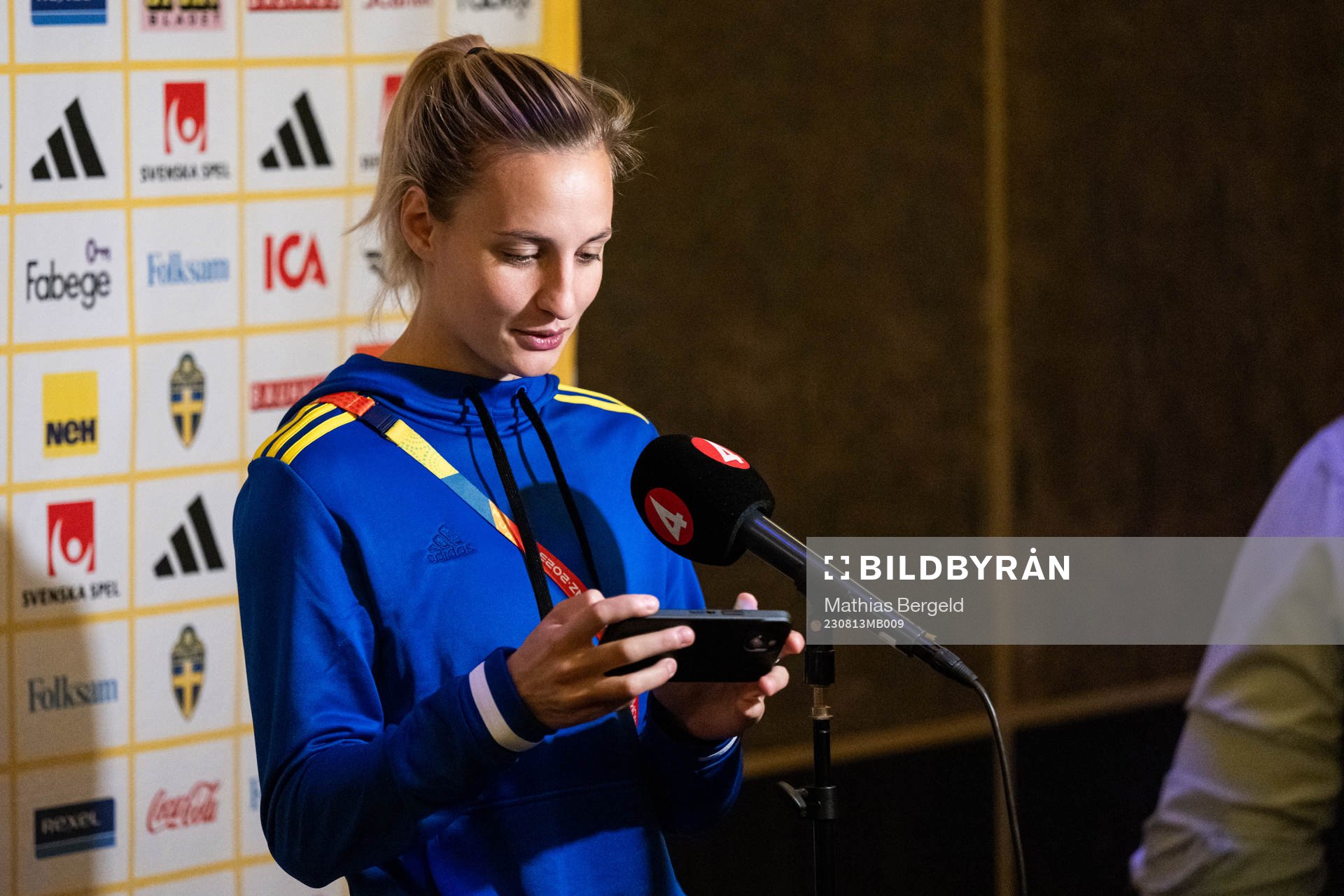 Nathalie Björn of the Swedish women's national football team is interviewed and reacts after being showed something on a mobile phone at a press event during the FIFA Women's World Cup on August 13, 2023 in Auckland.