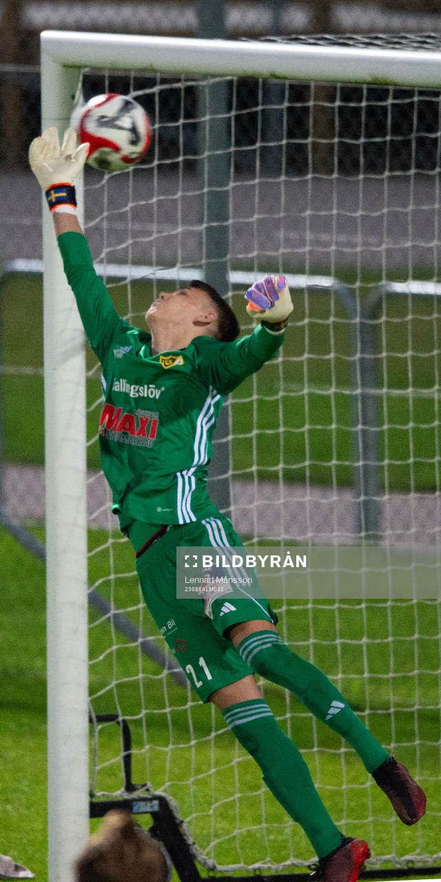 IFK Simrishamn placerar in en vinstgivande frispark i förlängningen bakom IFK Hässleholms målvakt Felix Persson i matchen i DM mellan IFK Hässleholm och IFK Simrishamn, i Hässleholm 14 augusti 2023.