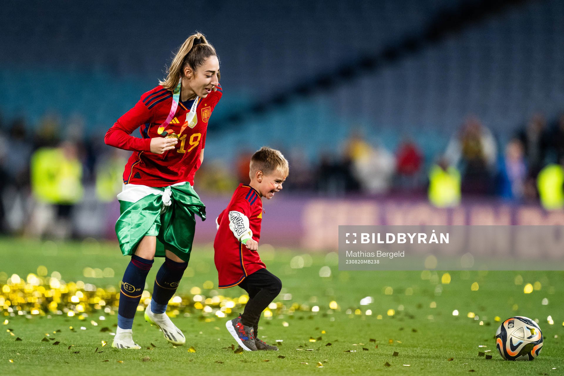 Olga Carmona of Spain plays football with a child as she