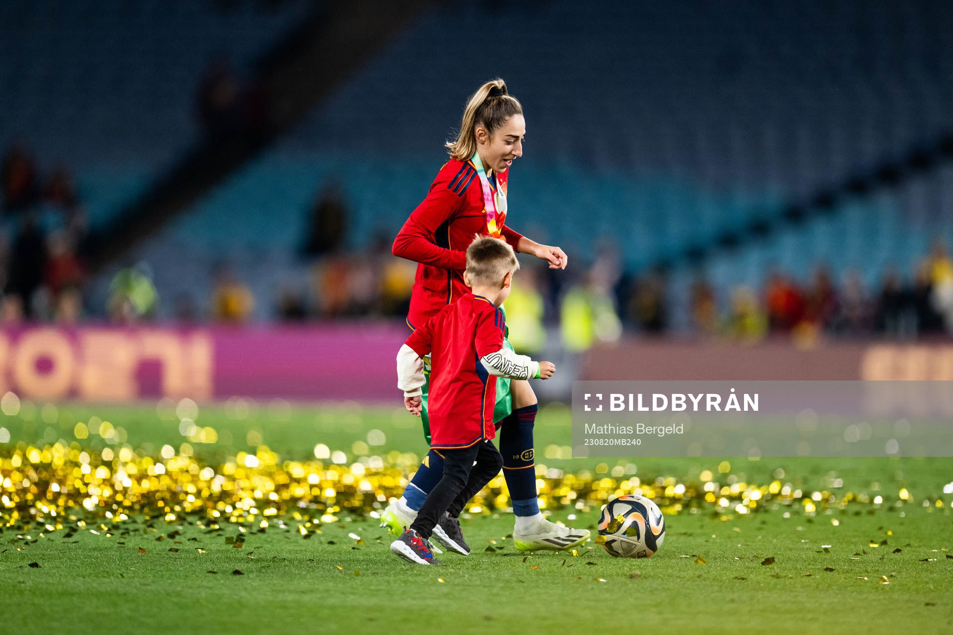 Olga Carmona of Spain plays football with a child as she