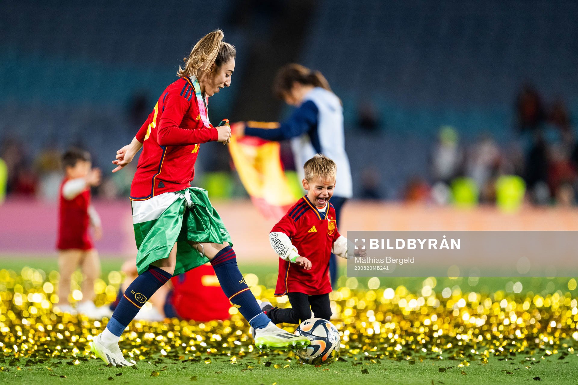 Olga Carmona of Spain plays football with a child as she