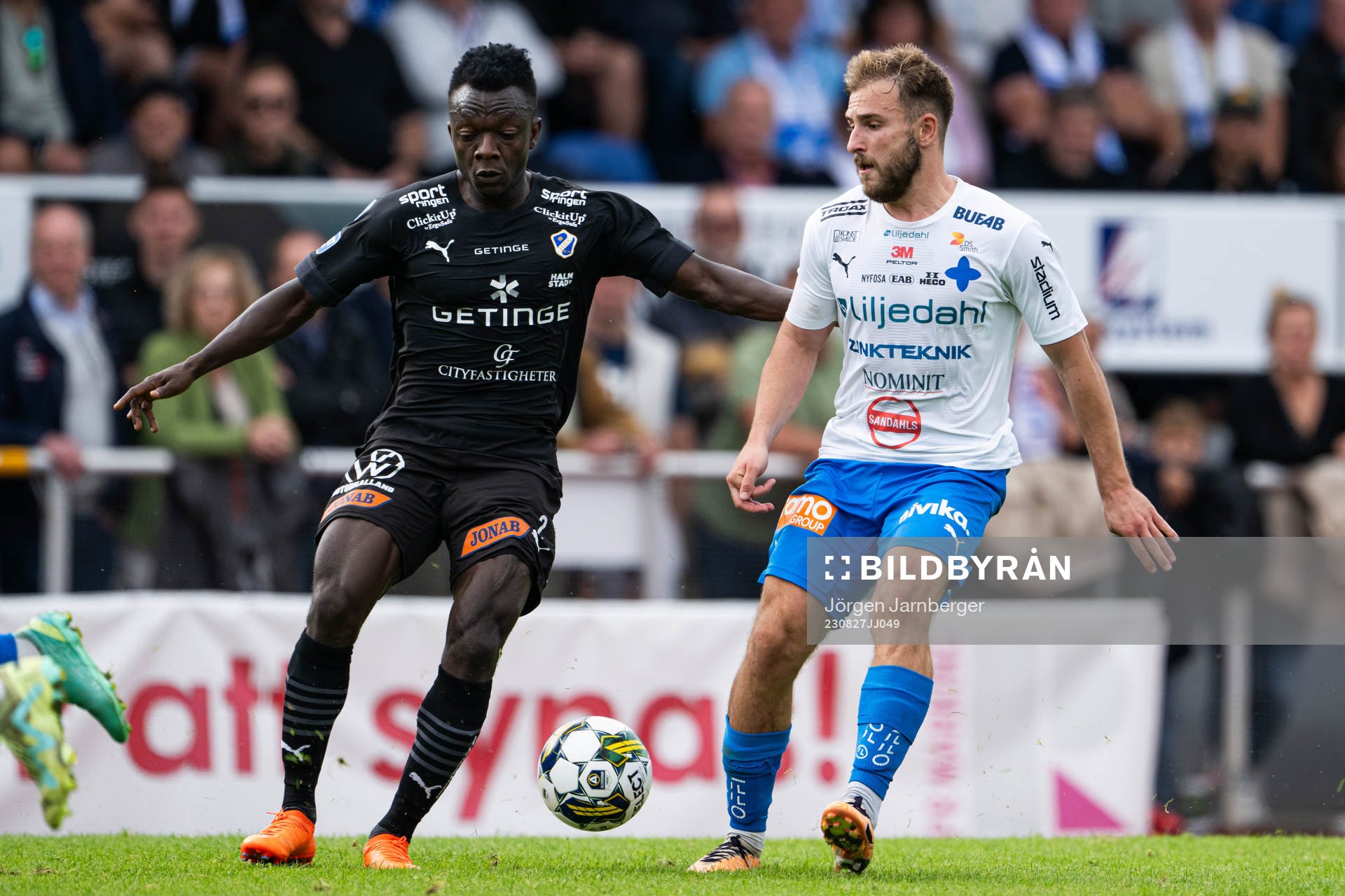 Halmstads Thomas Boakye och Värnamos Albion Ademi under fotbollsmatchen i Allsvenskan mellan Värnamo och Halmstad den 27 augusti 2023 i Värnamo.