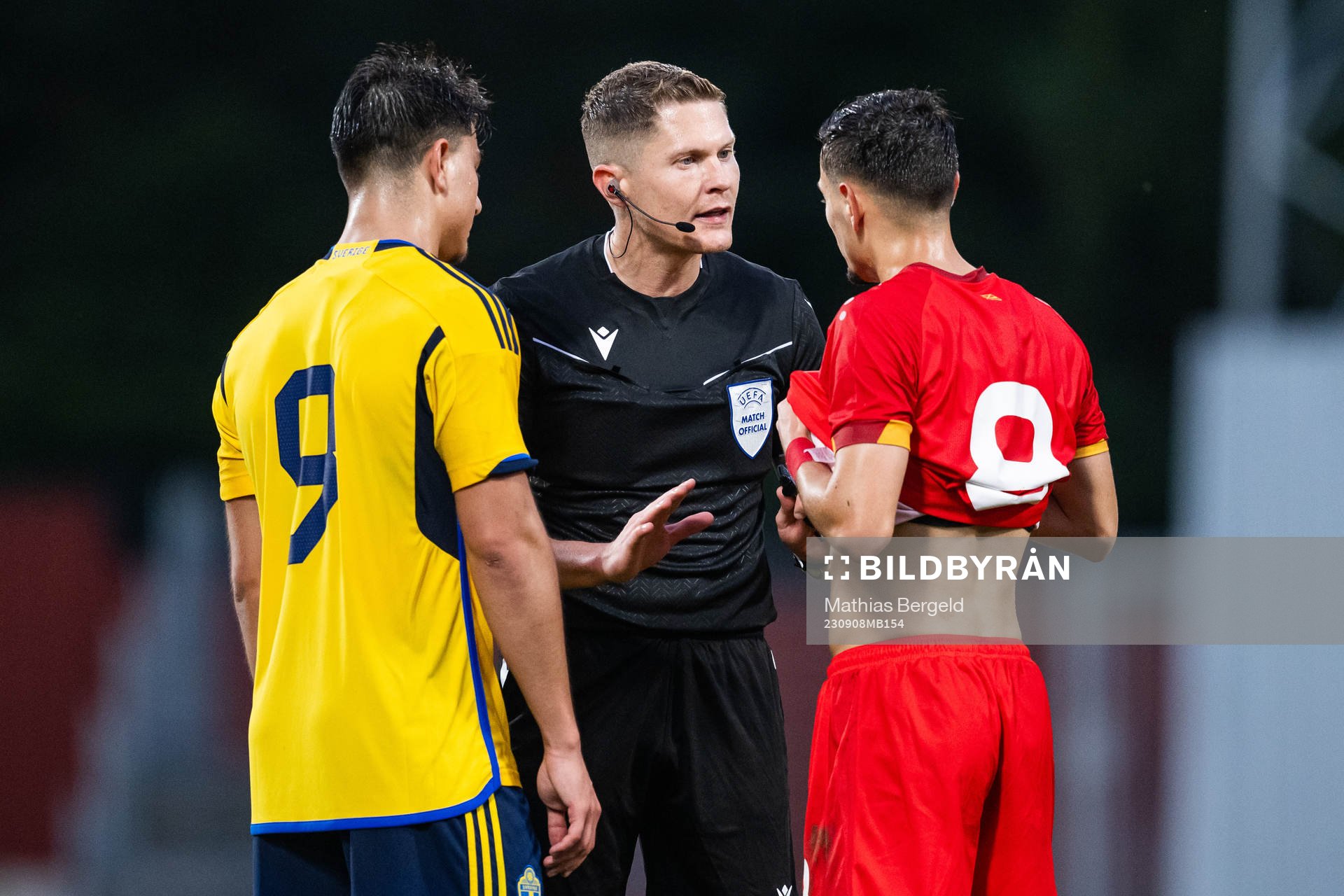 Jusef Erabi of Sweden, referee David Dickinson, and Ivan