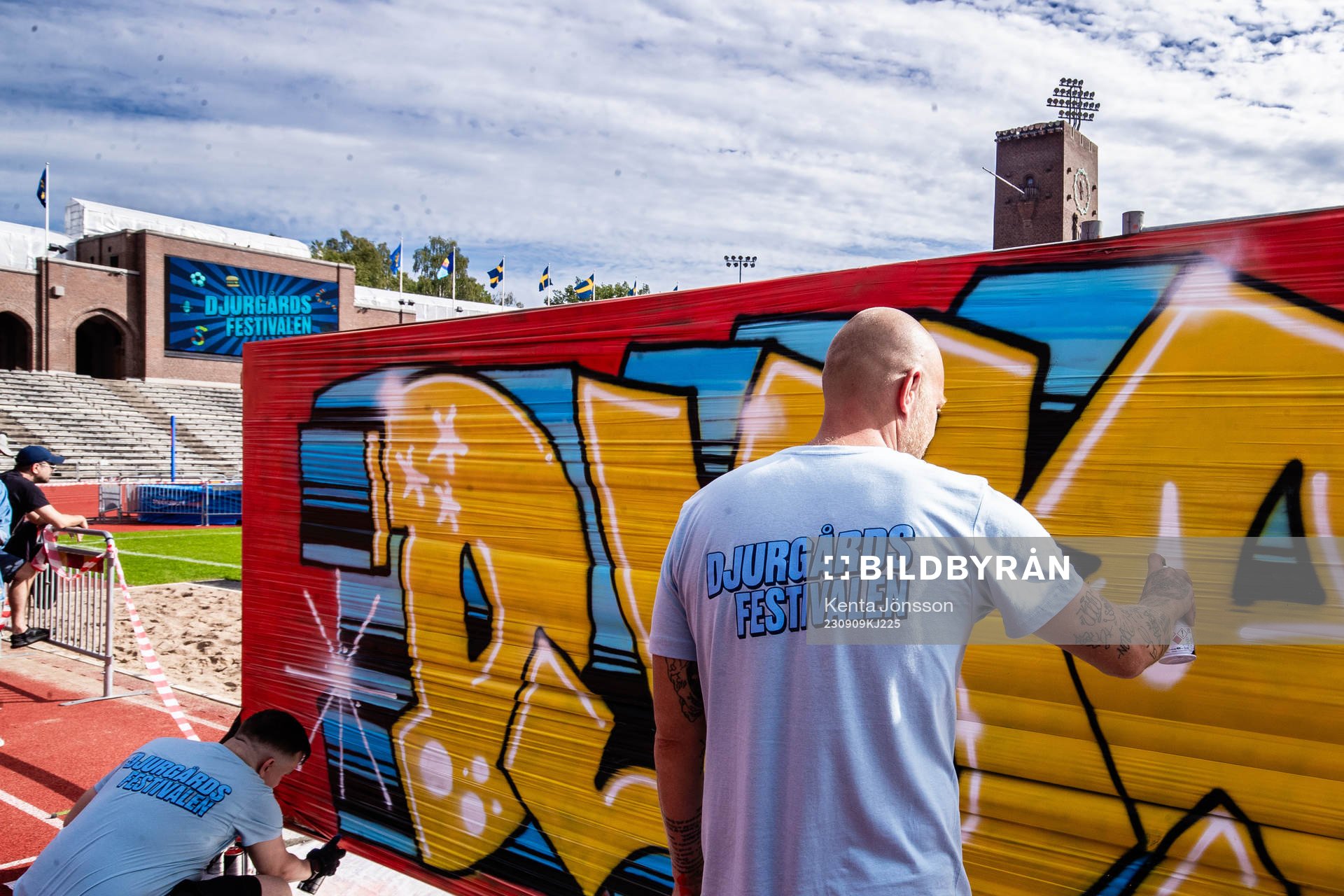 Personal målar på ett graffitiplank