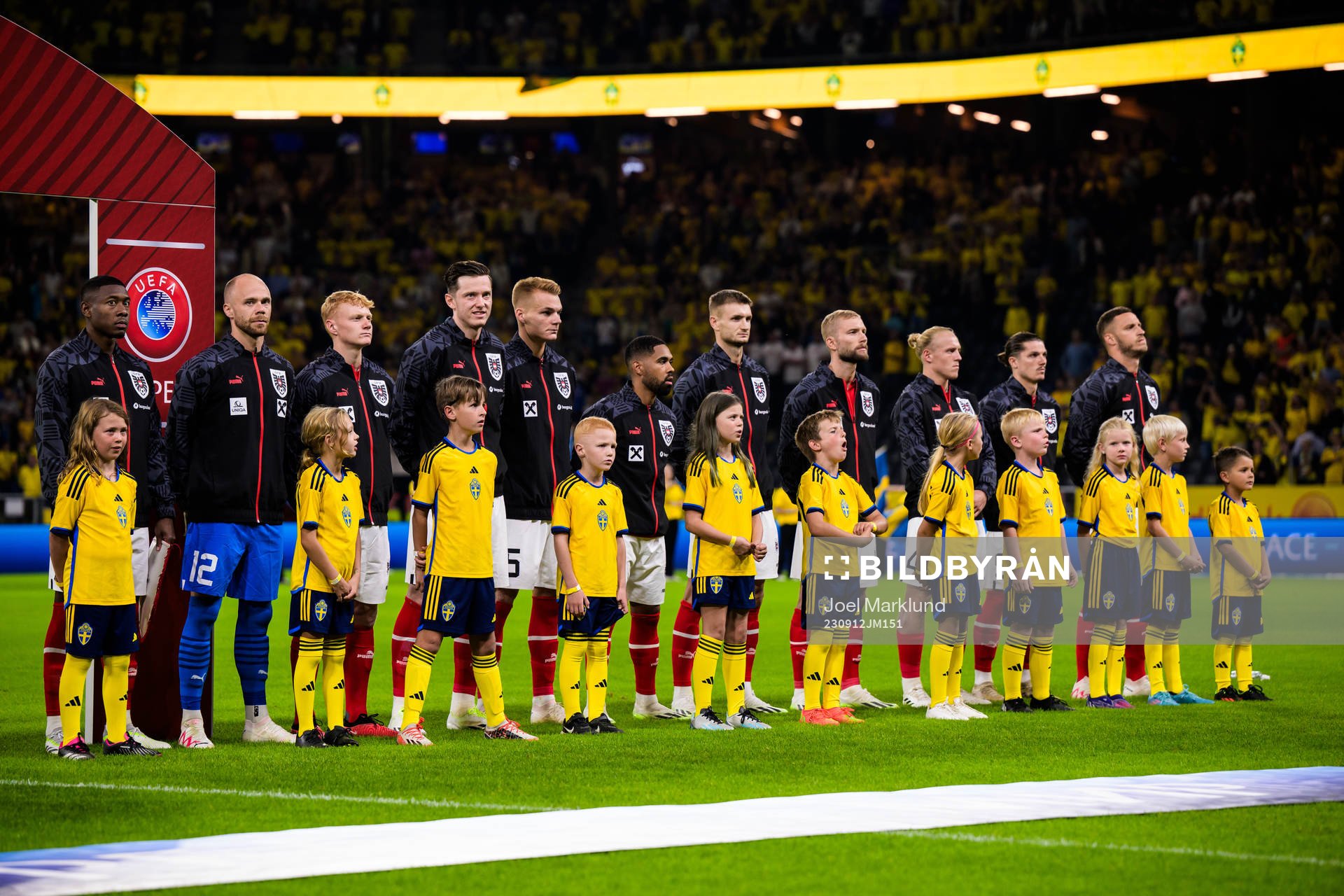 Swedish mascots in front of players of Austria