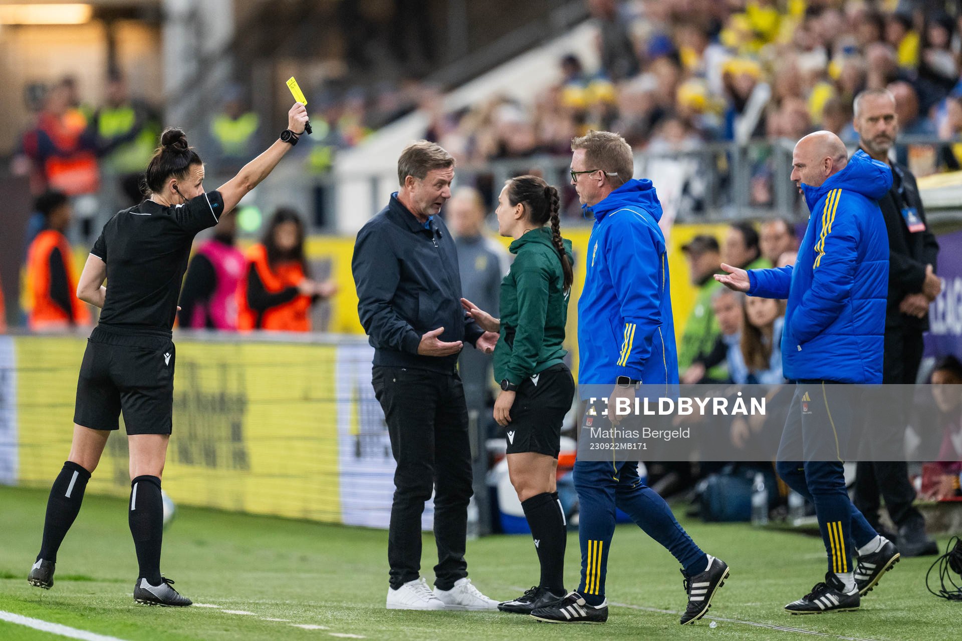 Referee Rebecca Welch gives a yellow card for someone at