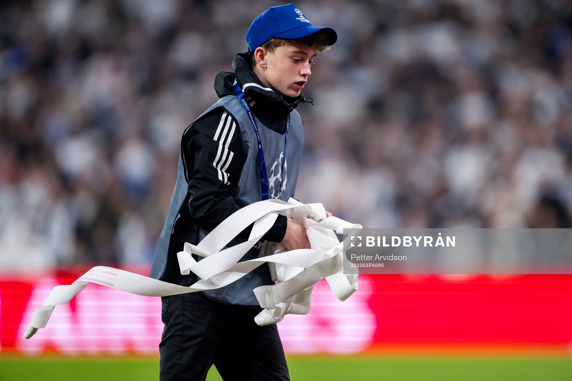 A ball boy picking up trash from the pitch