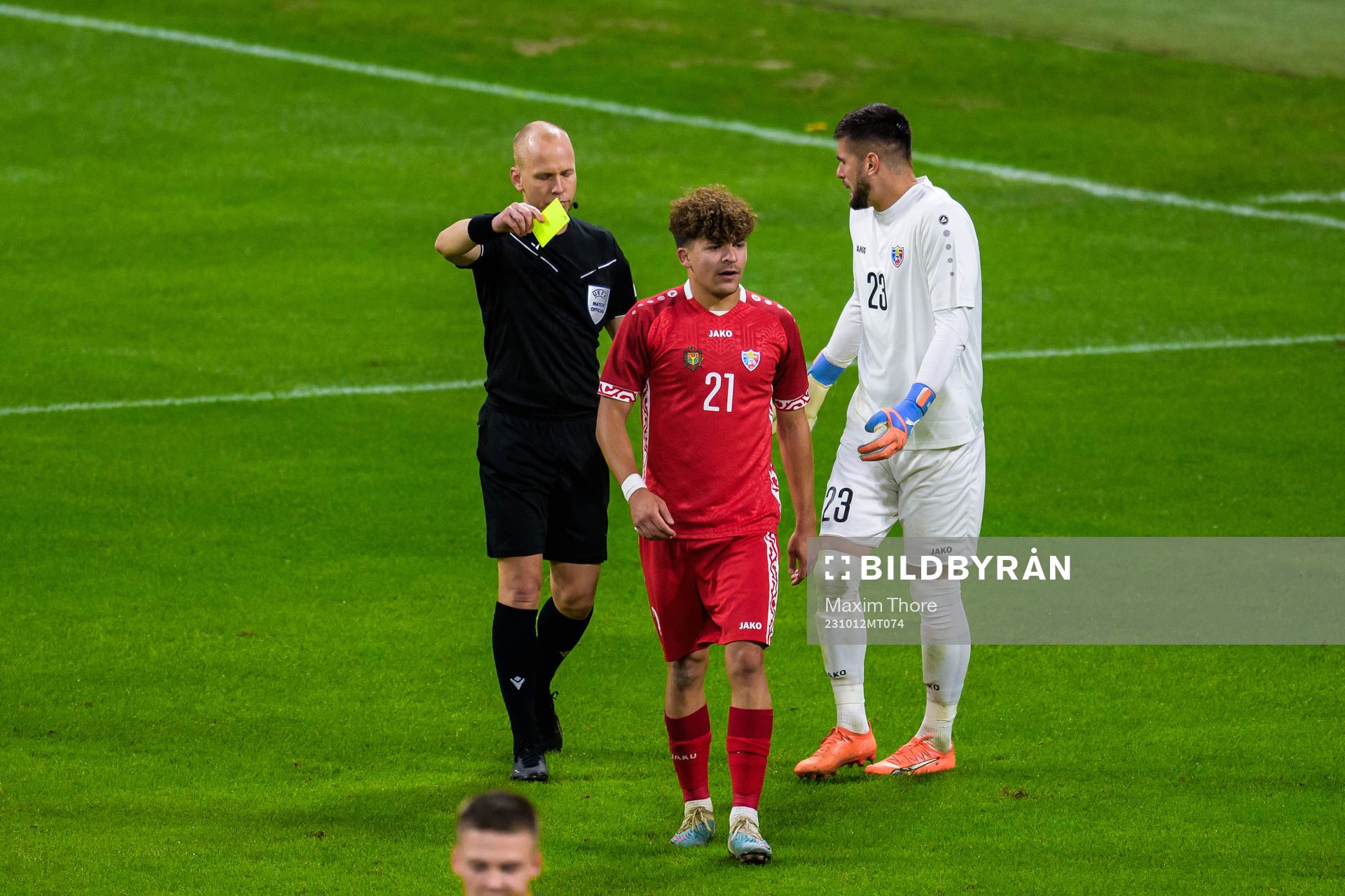 Ioan-Calin Revenco of Moldova receives a yellow card from