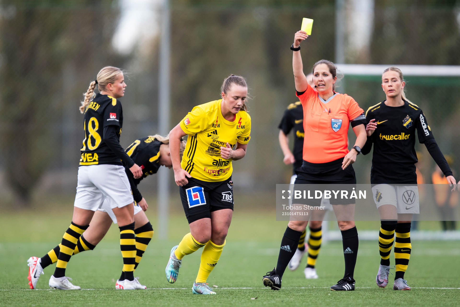 Domare Ulrica Löv delar ut ett gult kort till Gamla