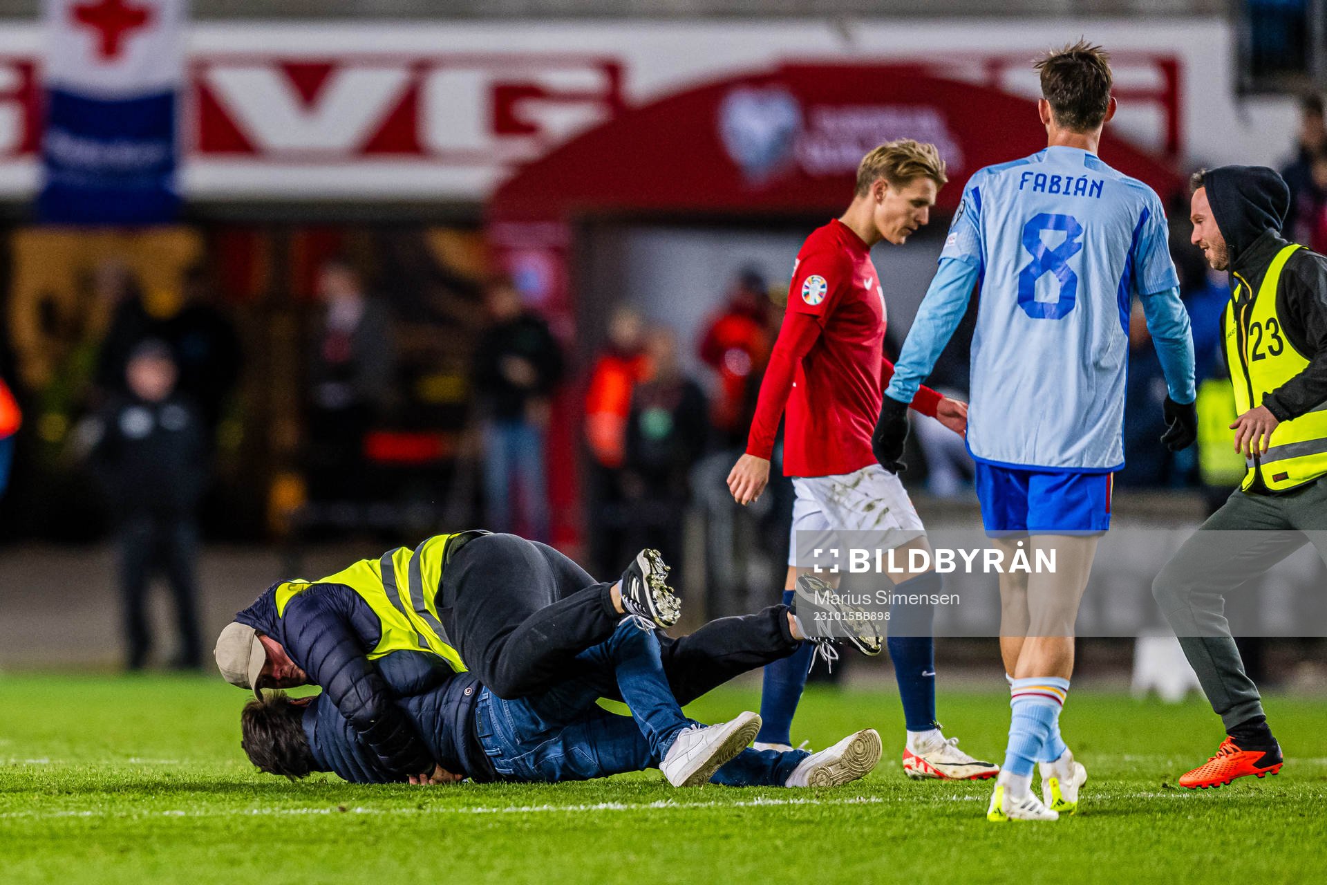 A steward is taking care of a pitch invader