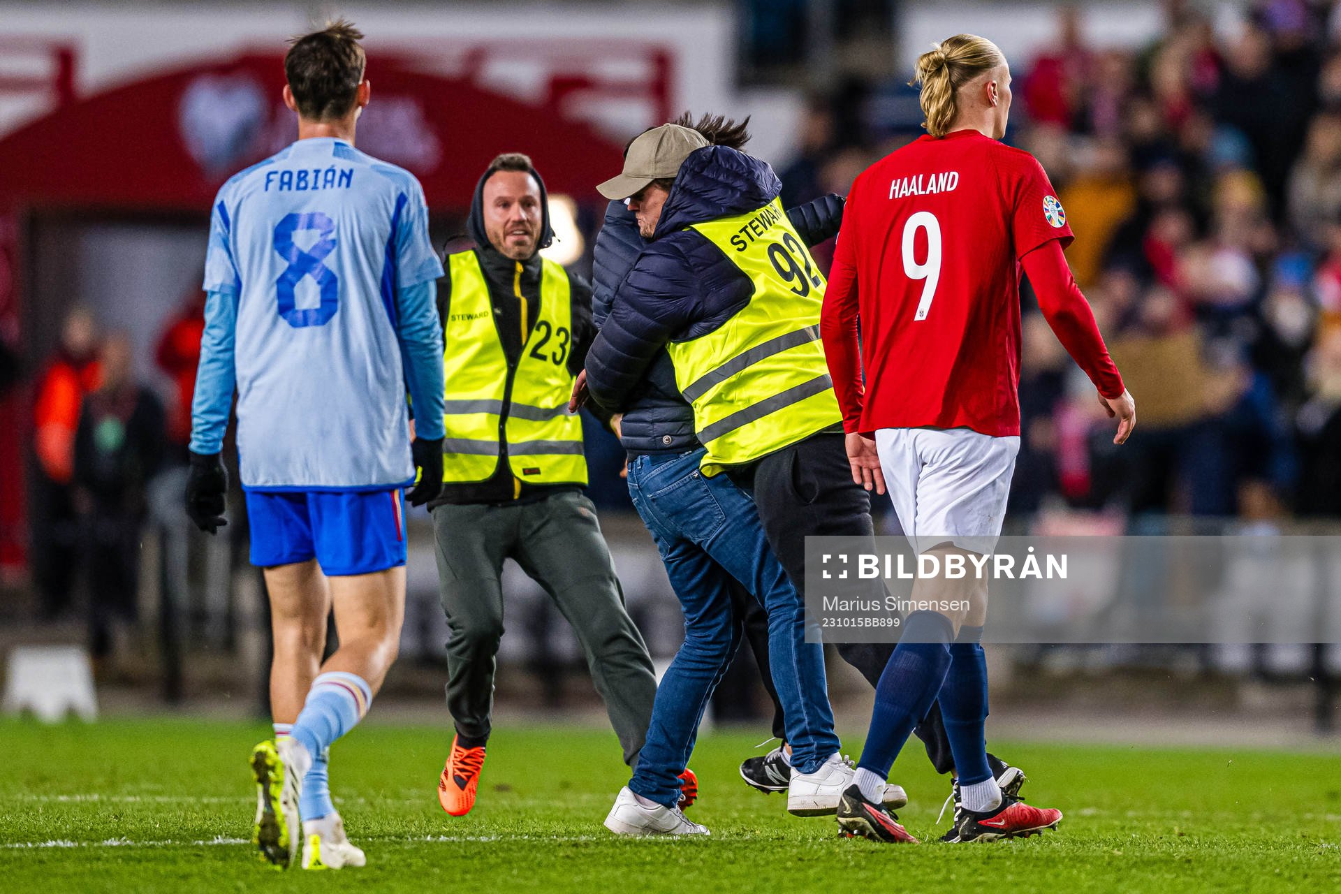 A steward is taking care of a pitch invader