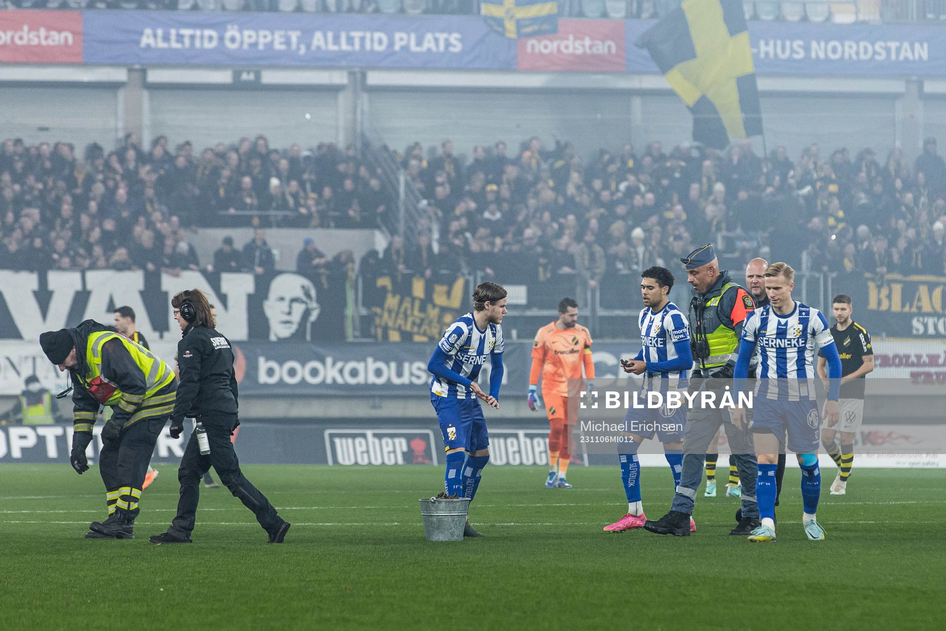 Spelare och personal plockar avfall från pryoteknik på