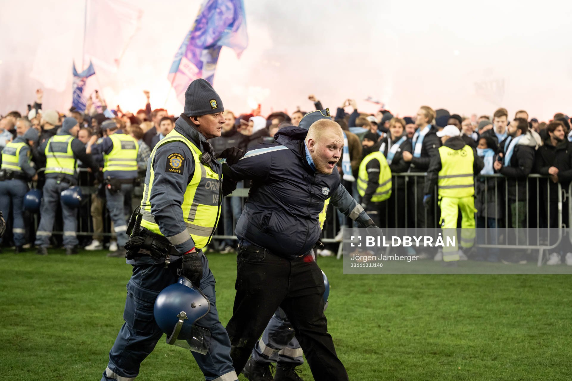 En supporter tas om hand av ordningsvakter innan
