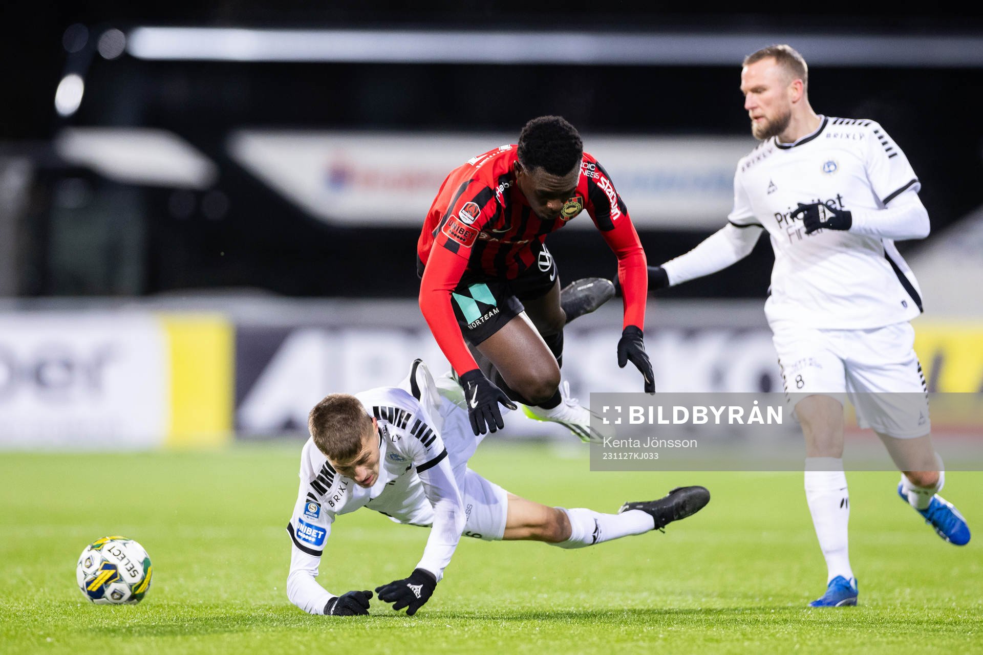 Brommapojkarnas Zeidane Inoussa i en kamp Utsiktens Erik Westermark och Alexander Faltsetas under fotbollsmatchen i kvalet till Allsvenskan mellan Brommapojkarna och Utsikten den 27 november 2023 i Stockholm.