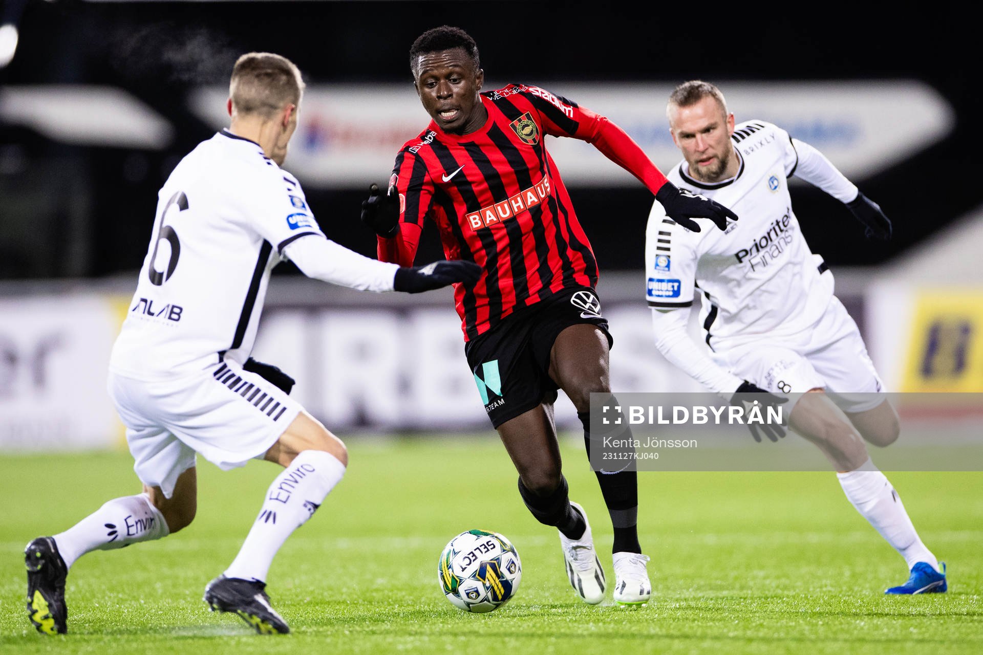 Brommapojkarnas Zeidane Inoussa i kamp med Utsiktens Erik Westermark och Alexander Faltsetas under fotbollsmatchen i kvalet till Allsvenskan mellan Brommapojkarna och Utsikten den 27 november 2023 i Stockholm.