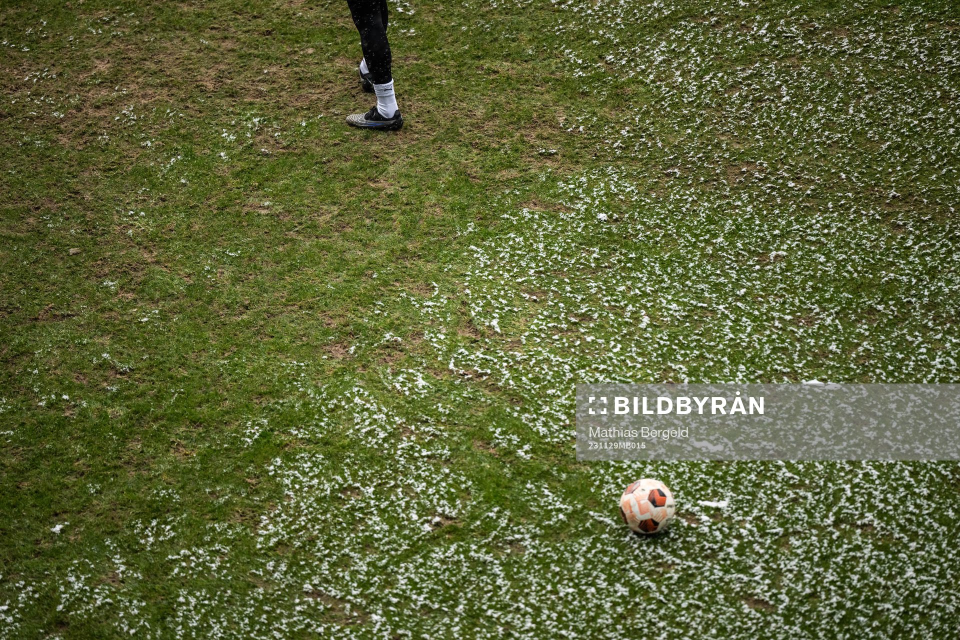Feet with football boots and snow