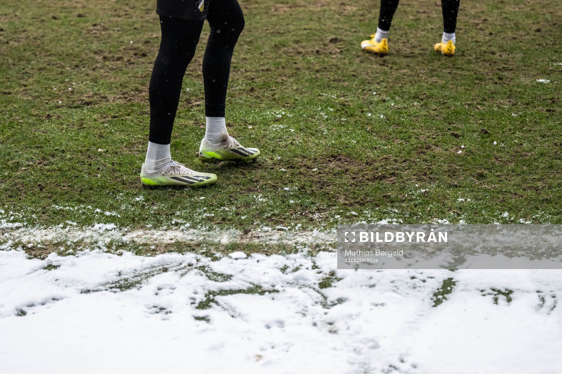 Feet with football boots and snow