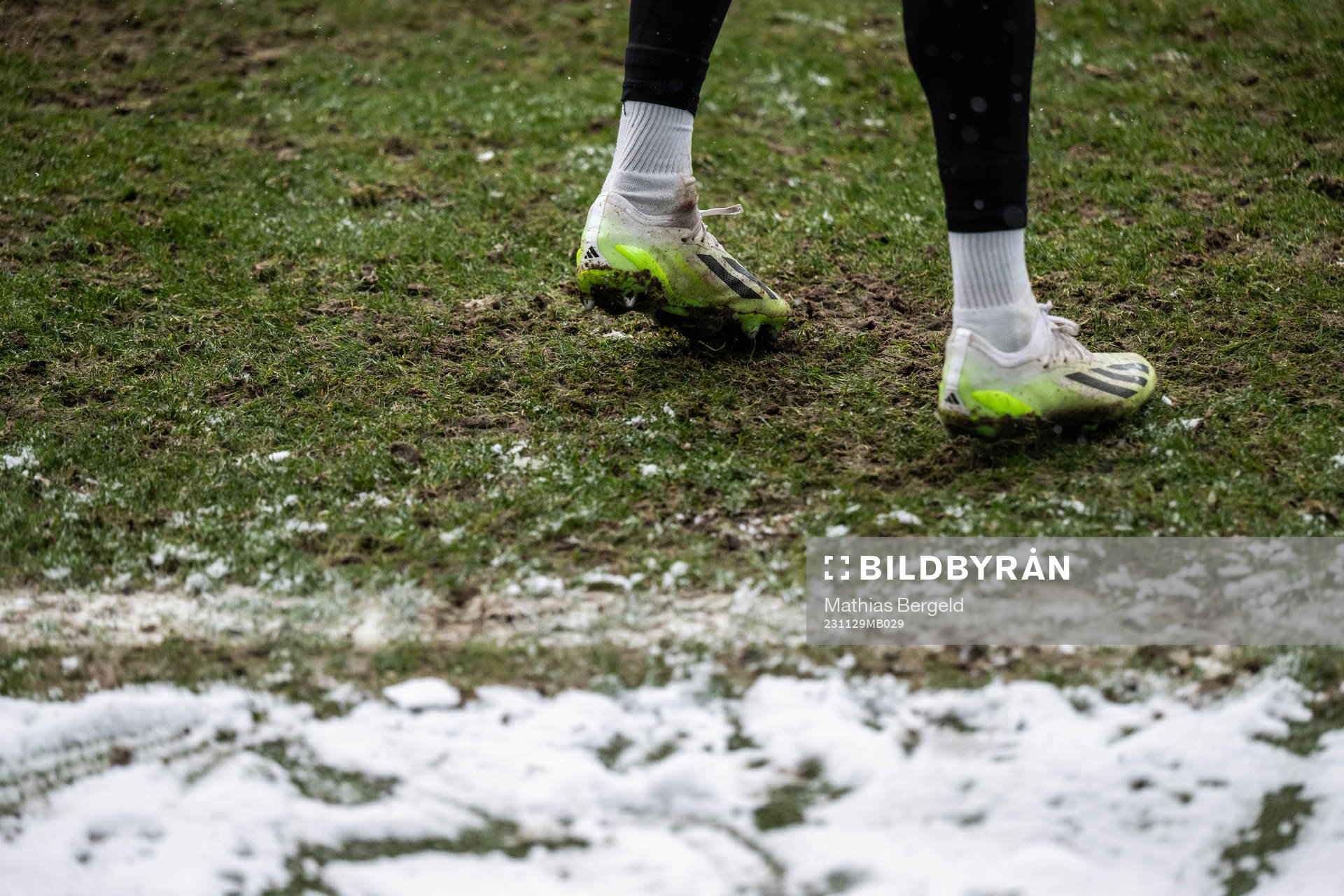 Feet with football boots and snow