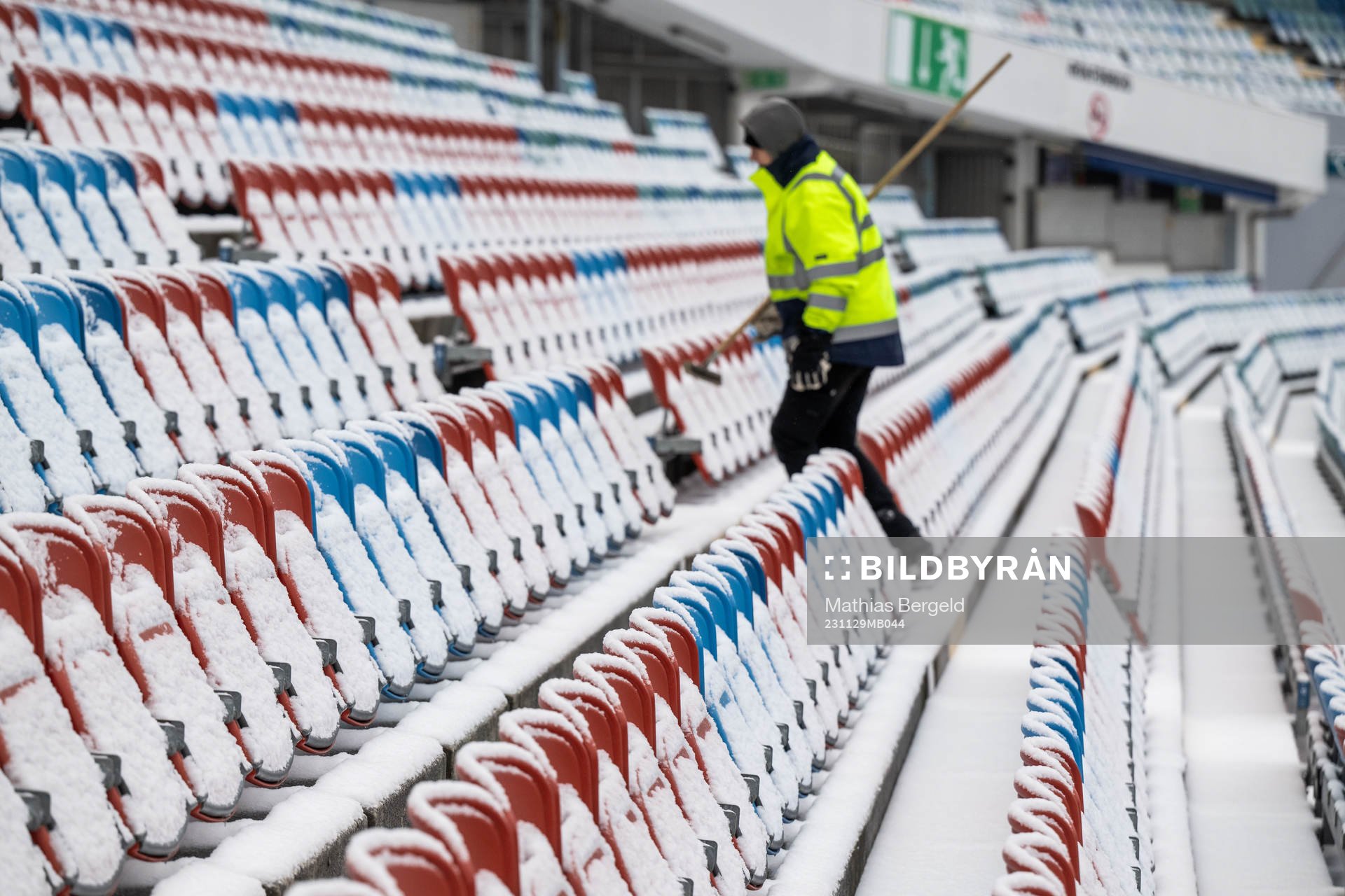 Snow at the seats as a worker walks past at Ullevi stadium