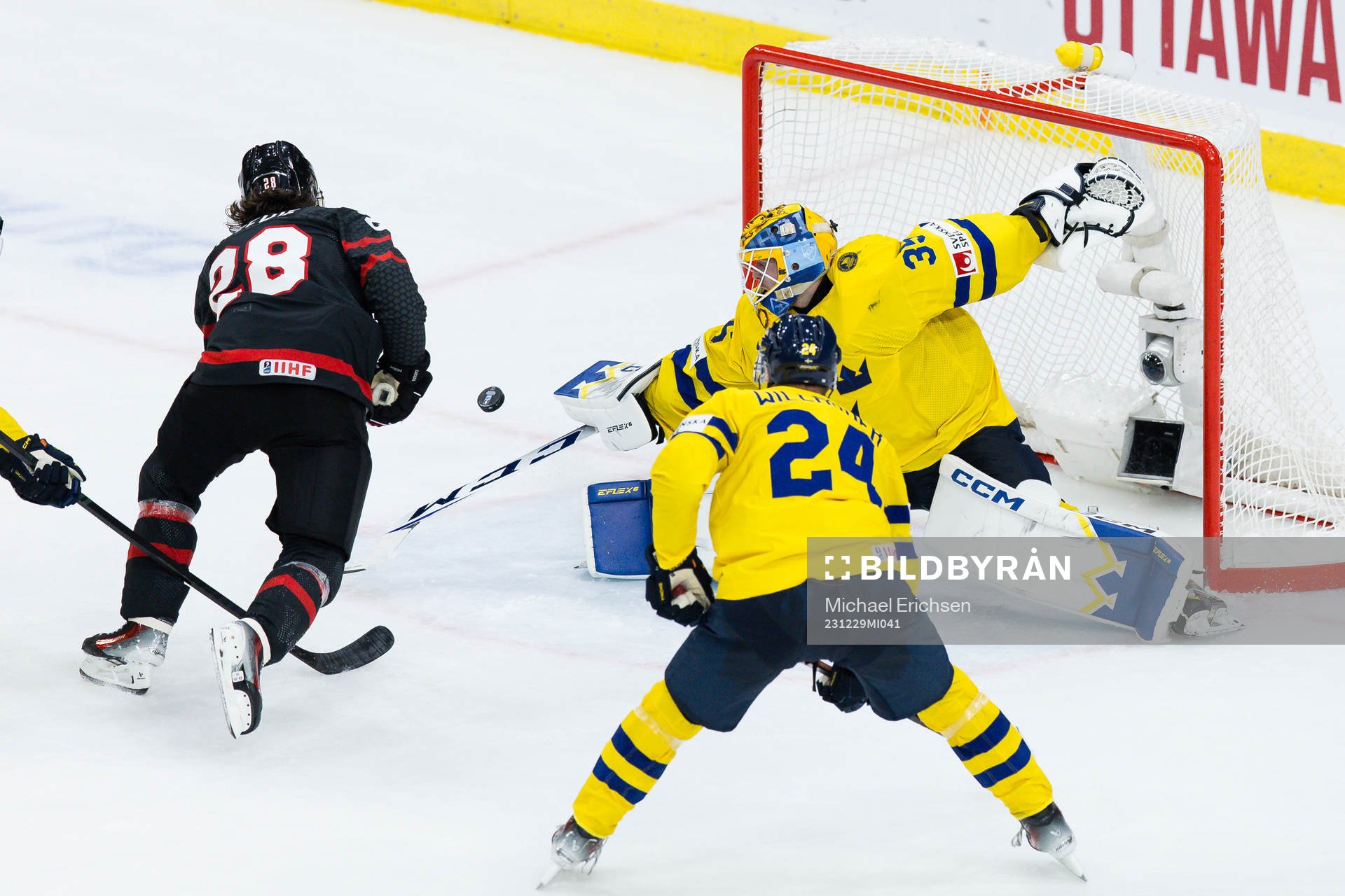 Goaltender Hugo Hävelid of Sweden and Conor Geekie of