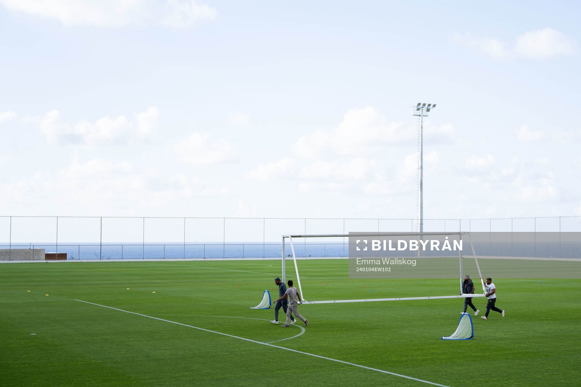 Builders carrying a goal frame