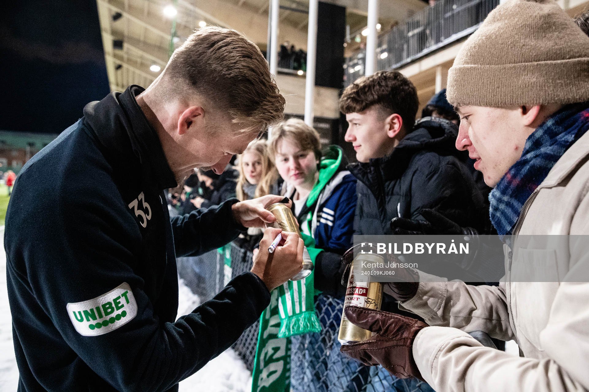 Fredrik Hammar skriver sin autograf på en ölburk