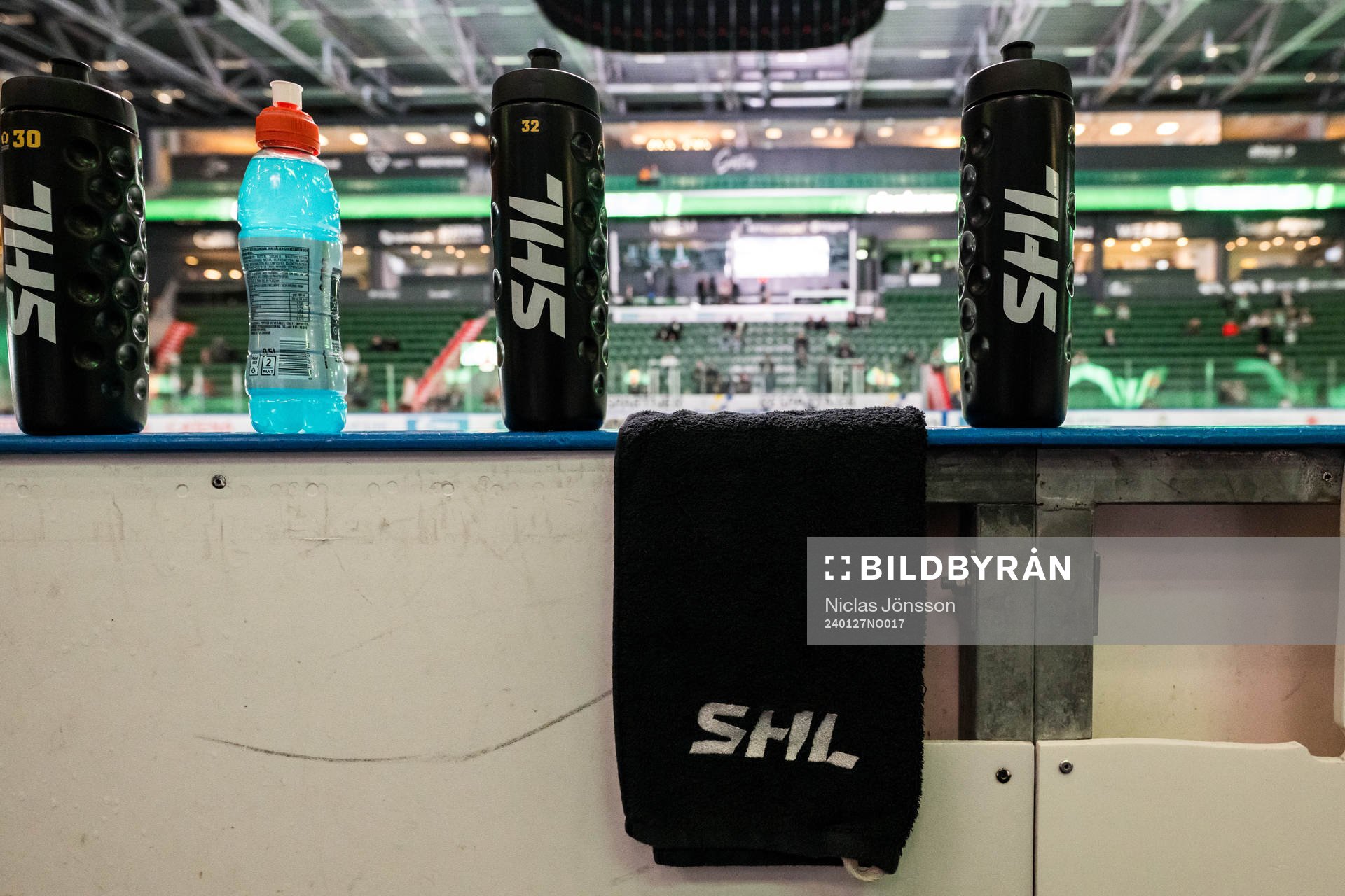 Vattenflaskor och handduk med texten ”SHL”