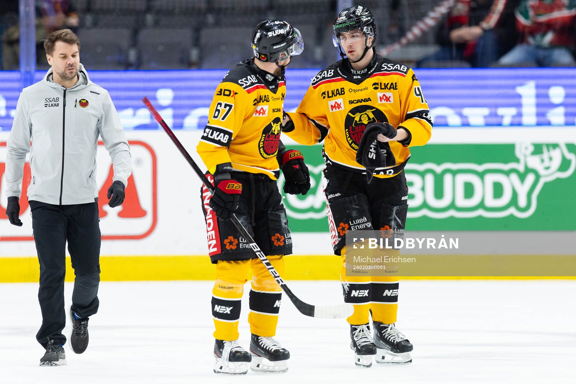 Luleås David Lilja lämnar isen med hjälp av Linus Omark