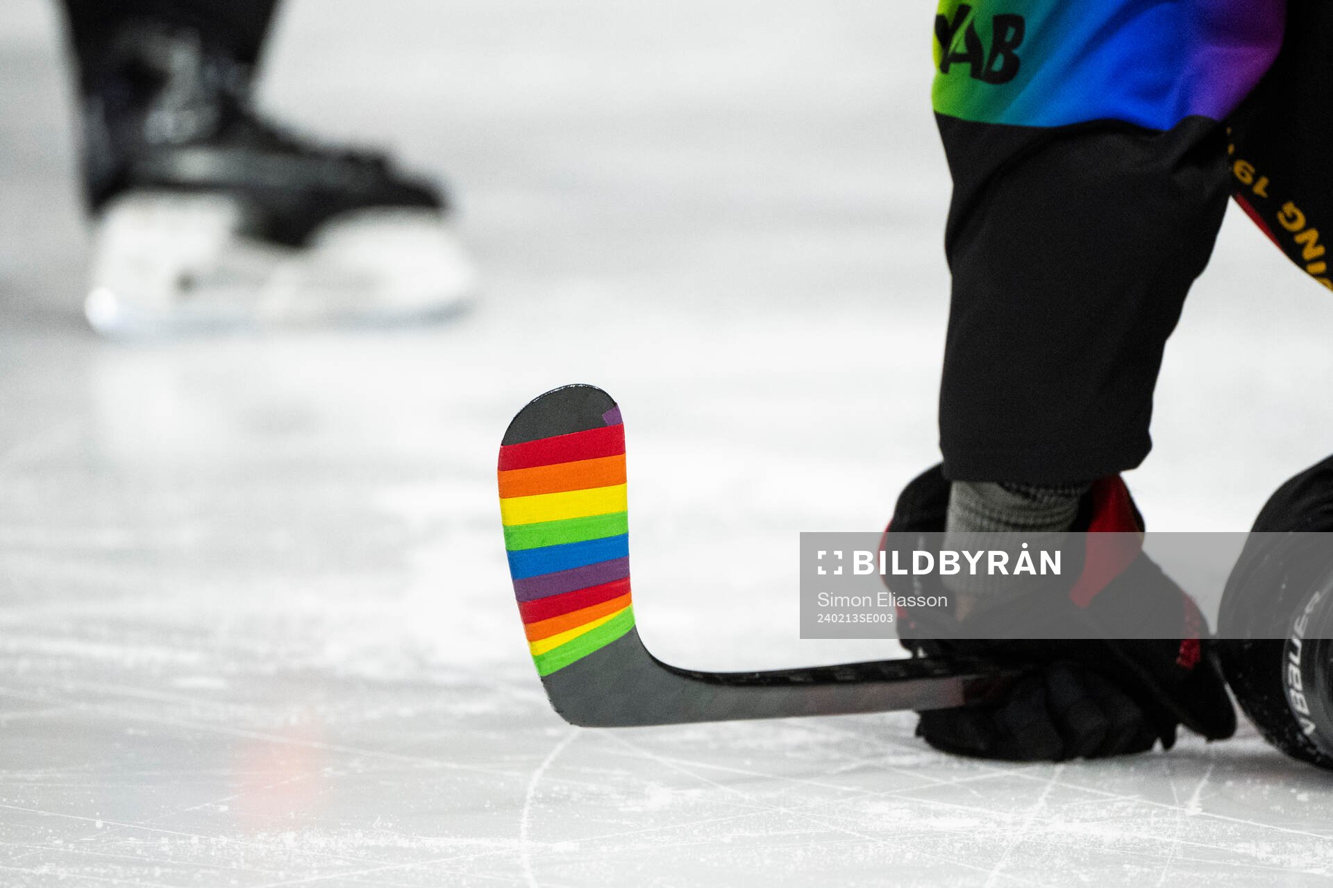 En klubba med pride-färgad tejp