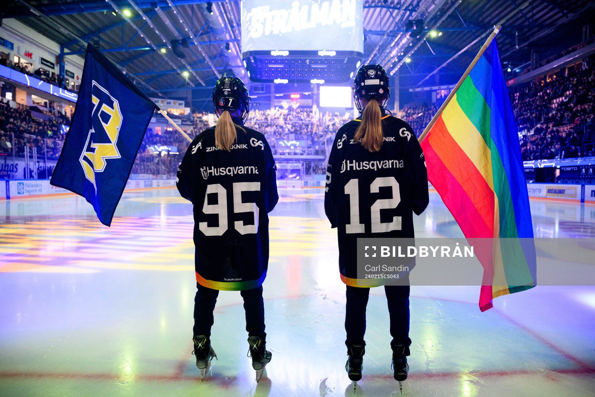 Flaggbärare med HV71s flagga och prideflaggan