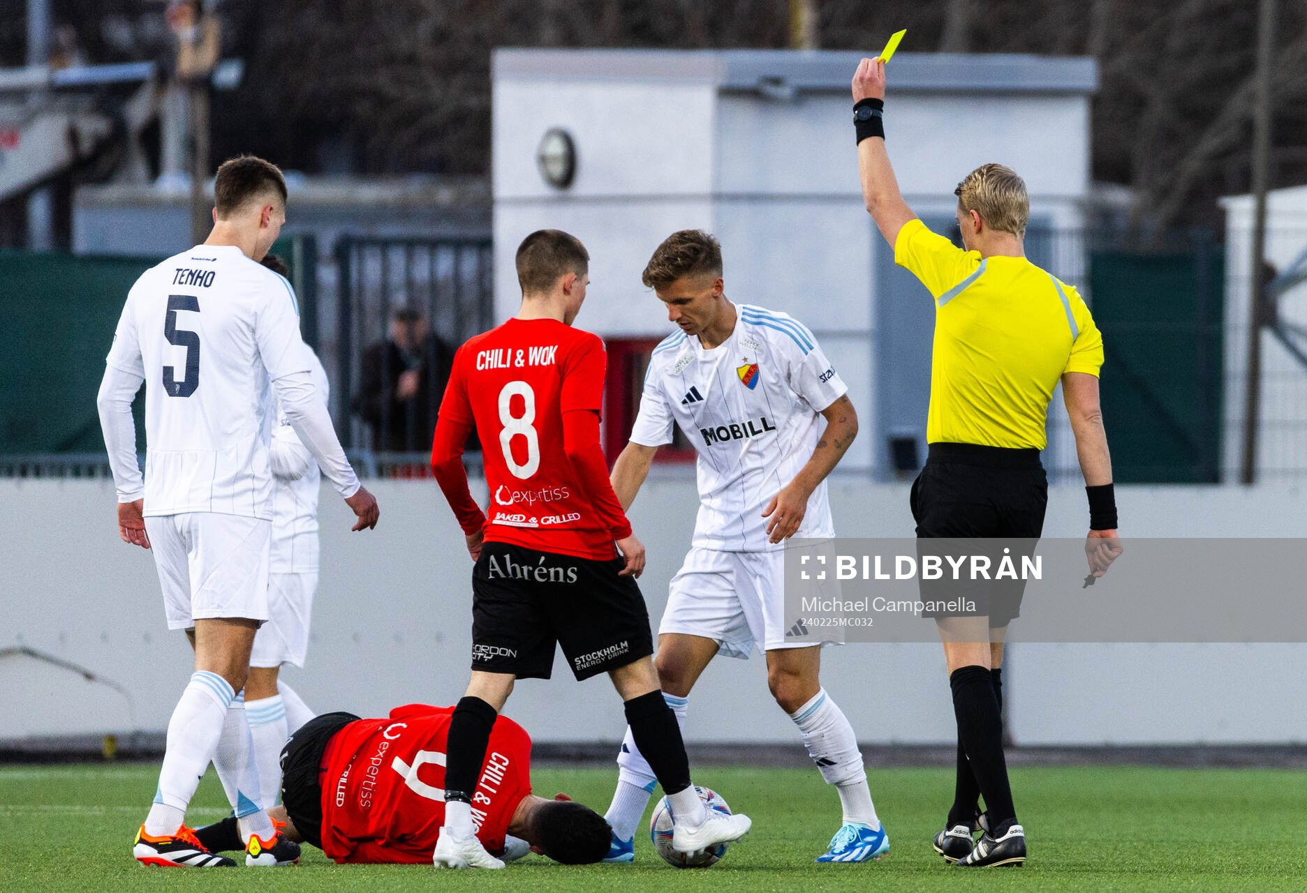 Domare Adam Ladebäck delar ut ett gult kort till