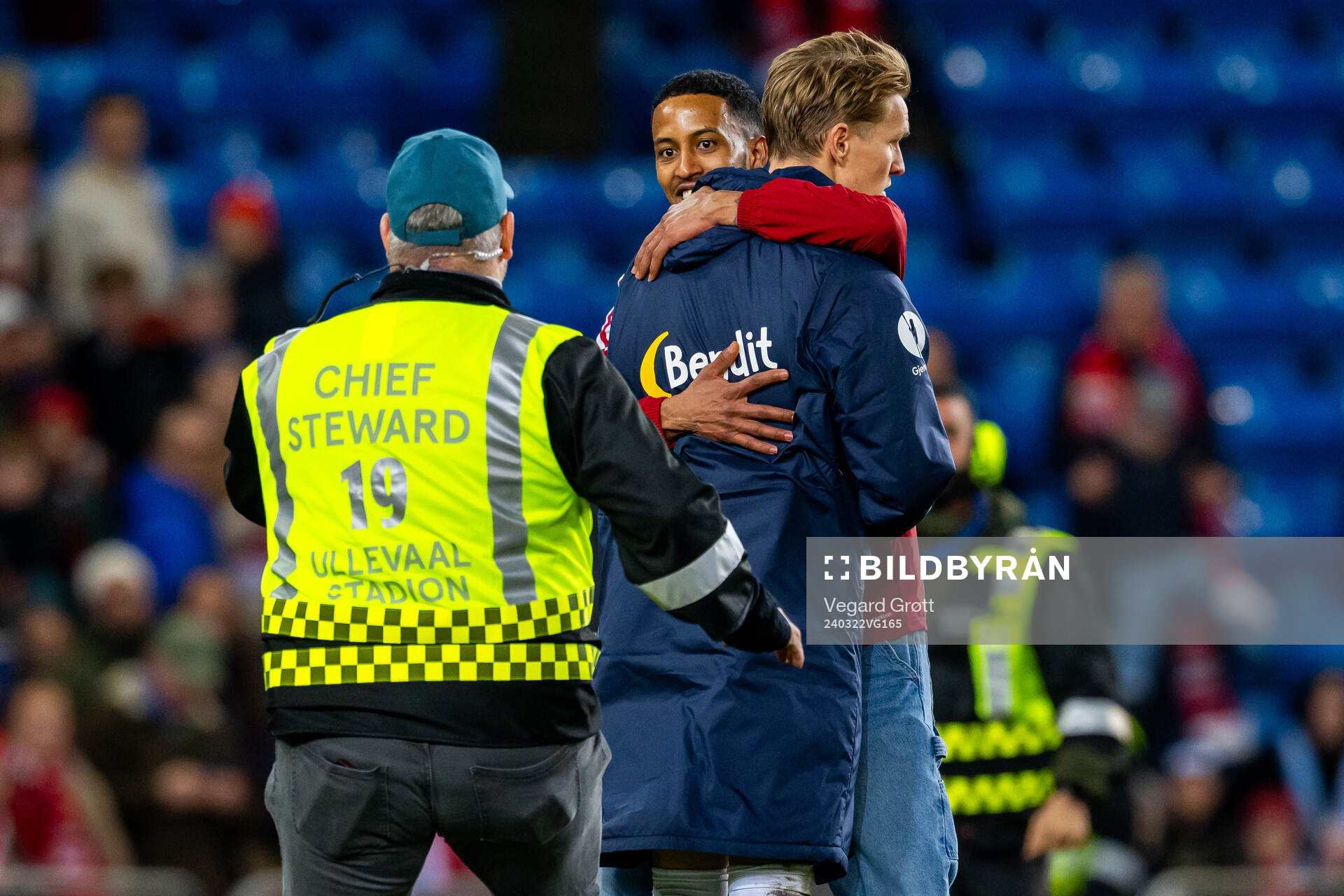 A pitch invader hugs Martin Ødegaard of Norway