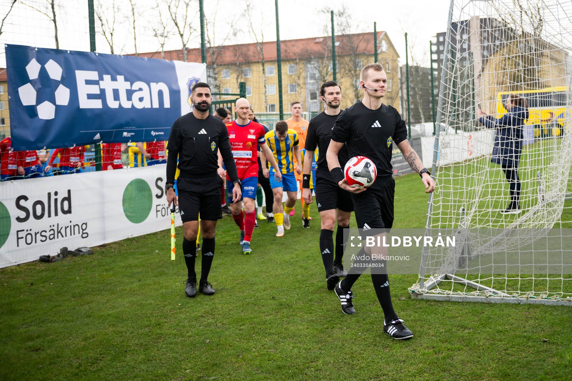 Spelare och domare gör entré inför fotbollsmatchen i Division 1 södra mellan Eskilsminne och Tvååkers IF den 30 mars 2024 i Helsingborg.