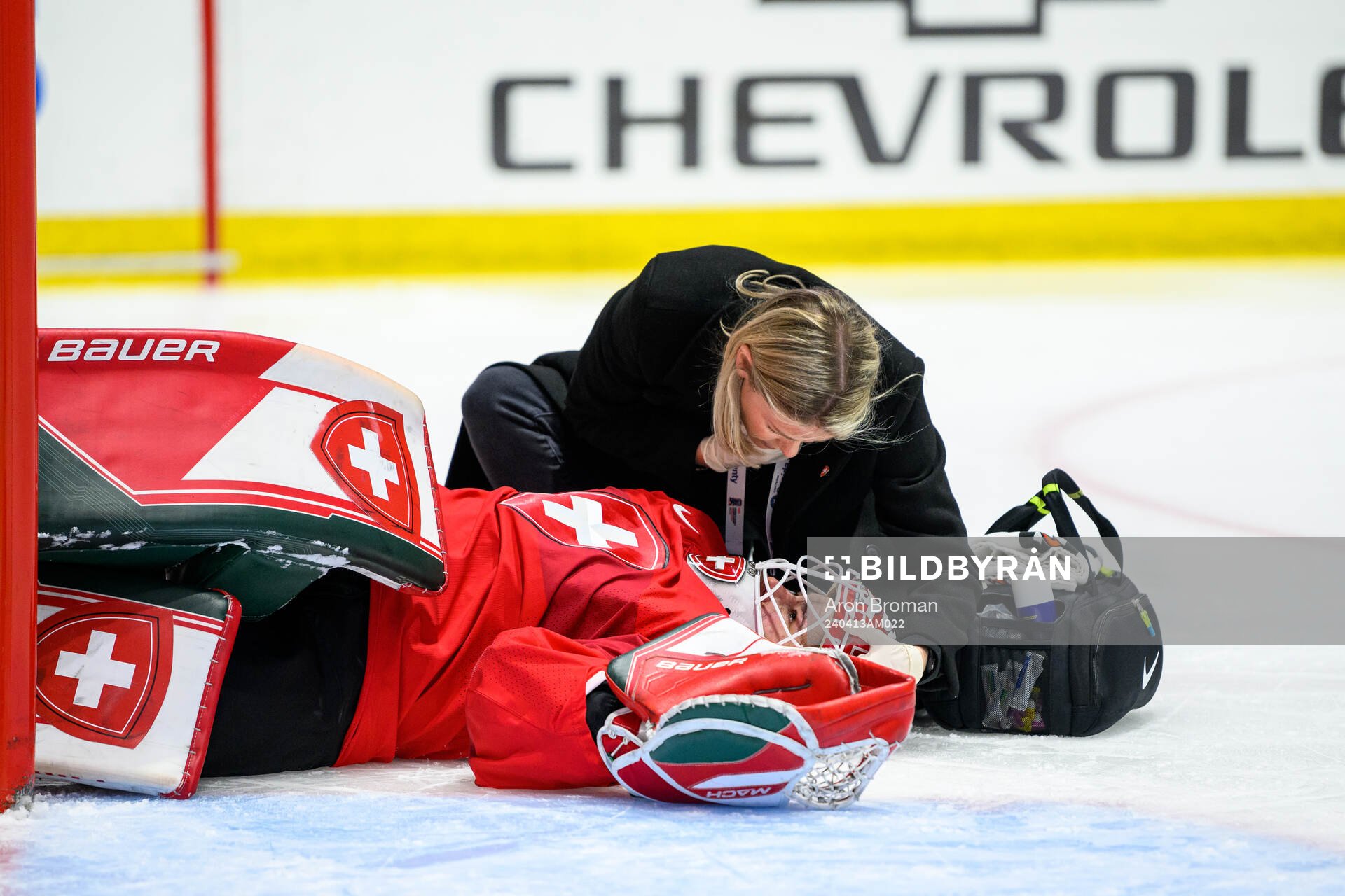 Goaltender Andrea Braendli of Switzerland receives medical