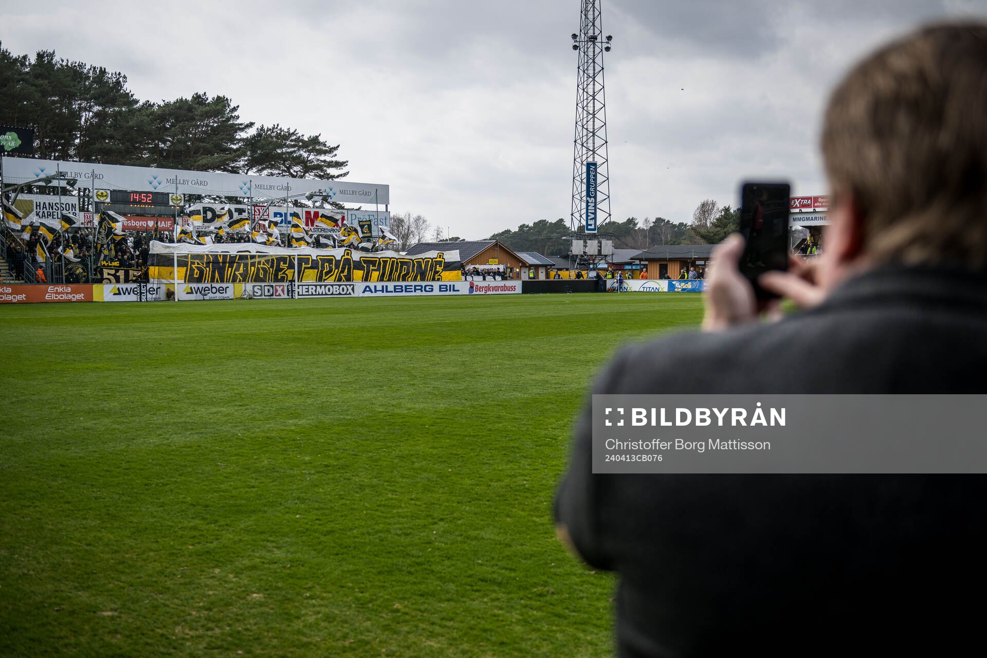 En funktionär fotograferar AIKs supportrar
