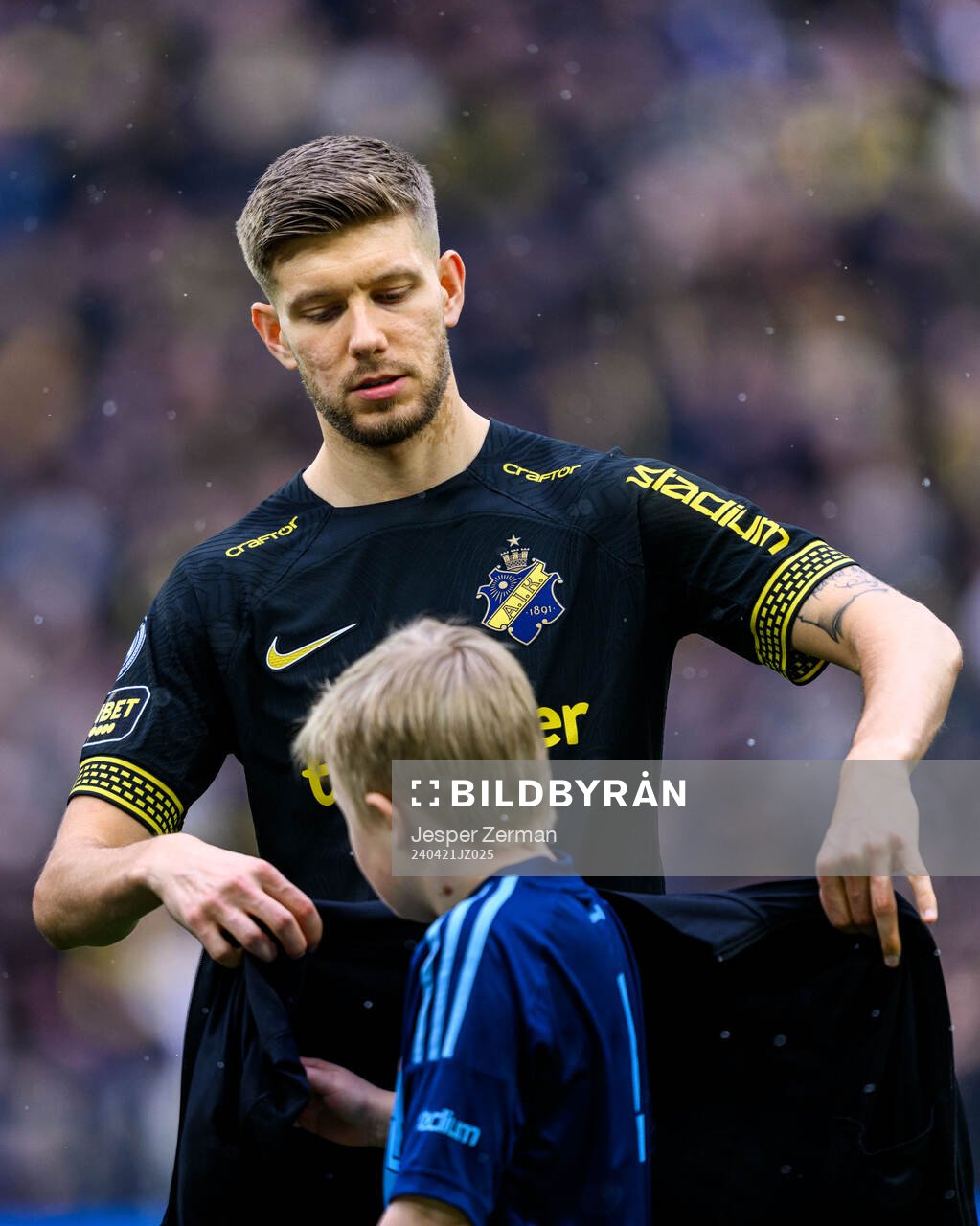 AIKs Anton Salétros ger sin jacka till en maskot under fotbollsmatchen i Allsvenskan mellan AIK och Djurgården den 21 april 2024 i Stockholm.