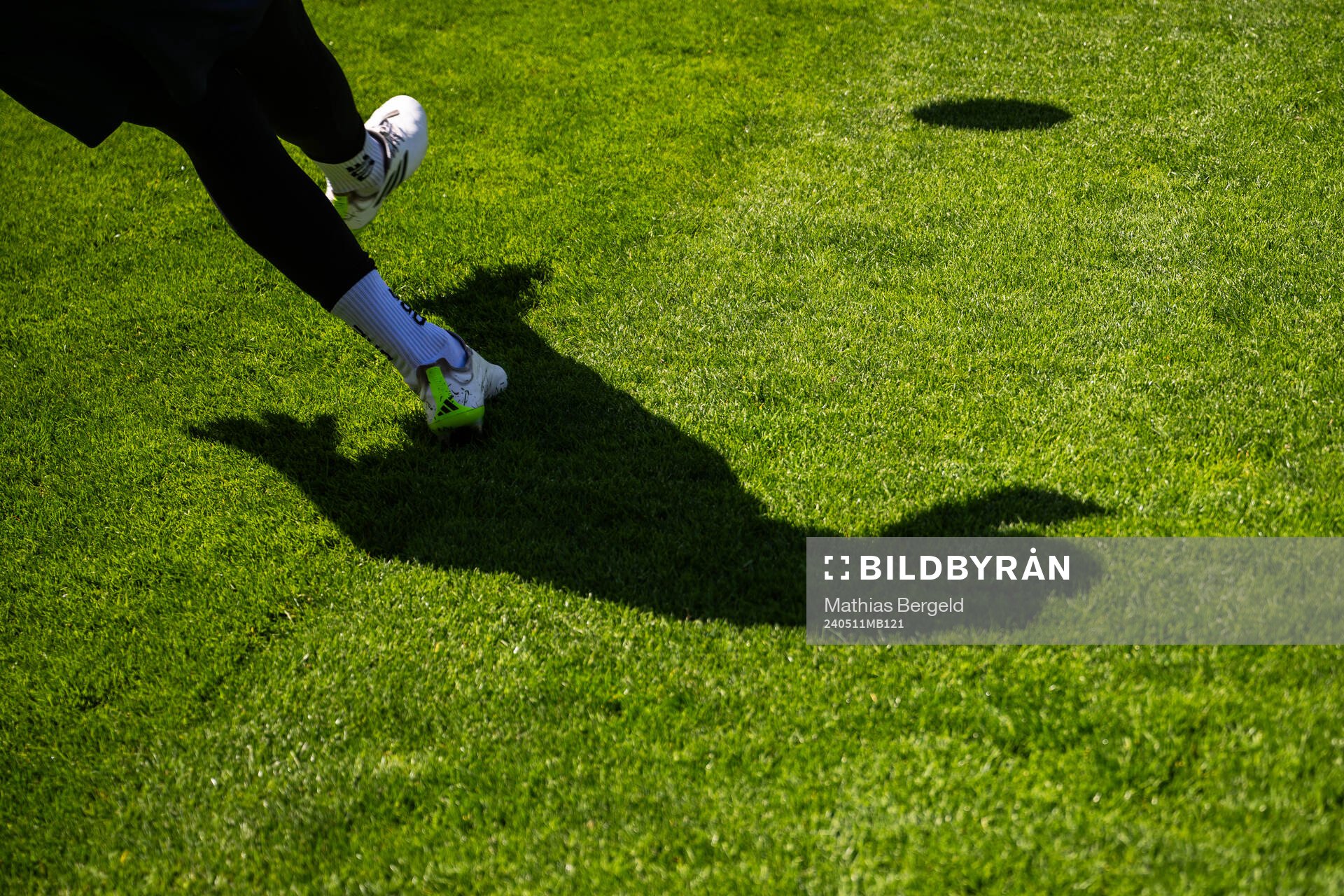 En skugga av en spelare som skjuter en boll inför fotbollsmatchen i Allsvenskan mellan Halmstad och Mjällby den 11 maj 2024 i Halmstad. 