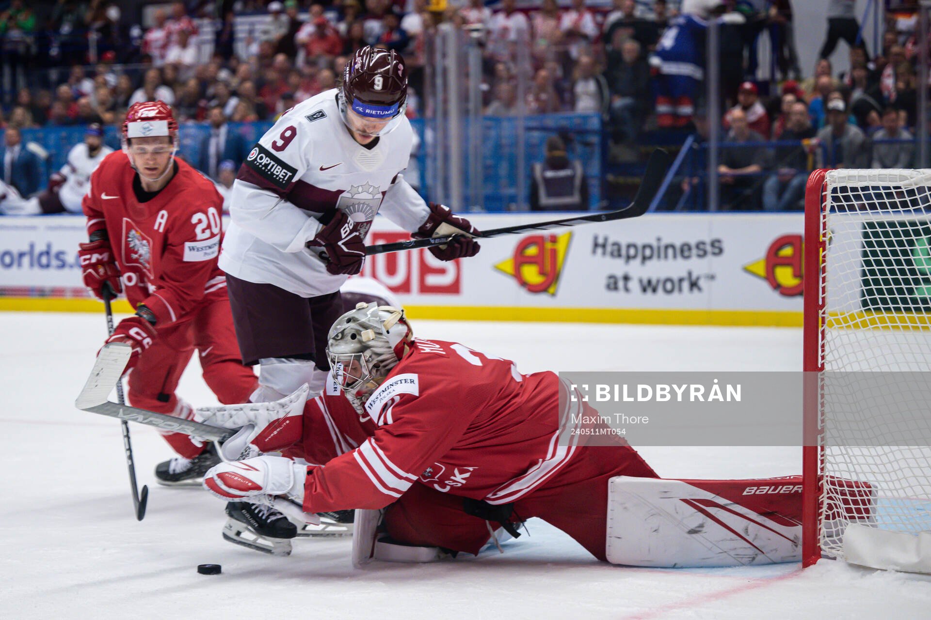 Renars Krastenbergs of Latvia and goaltender John Murray of
