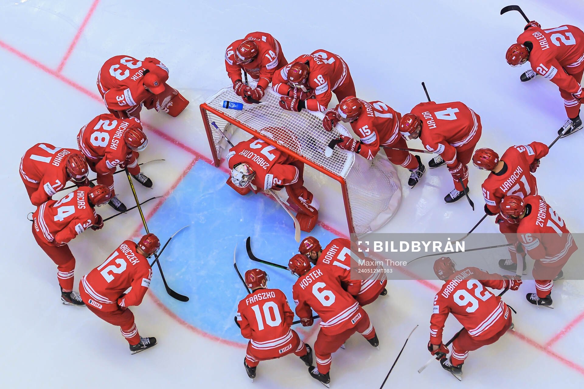 Players gather around goaltender David Zabolotny of Poland