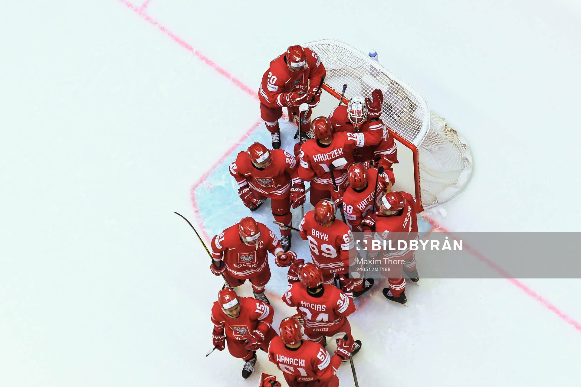 Goaltender David Zabolotny of Poland is embraced by