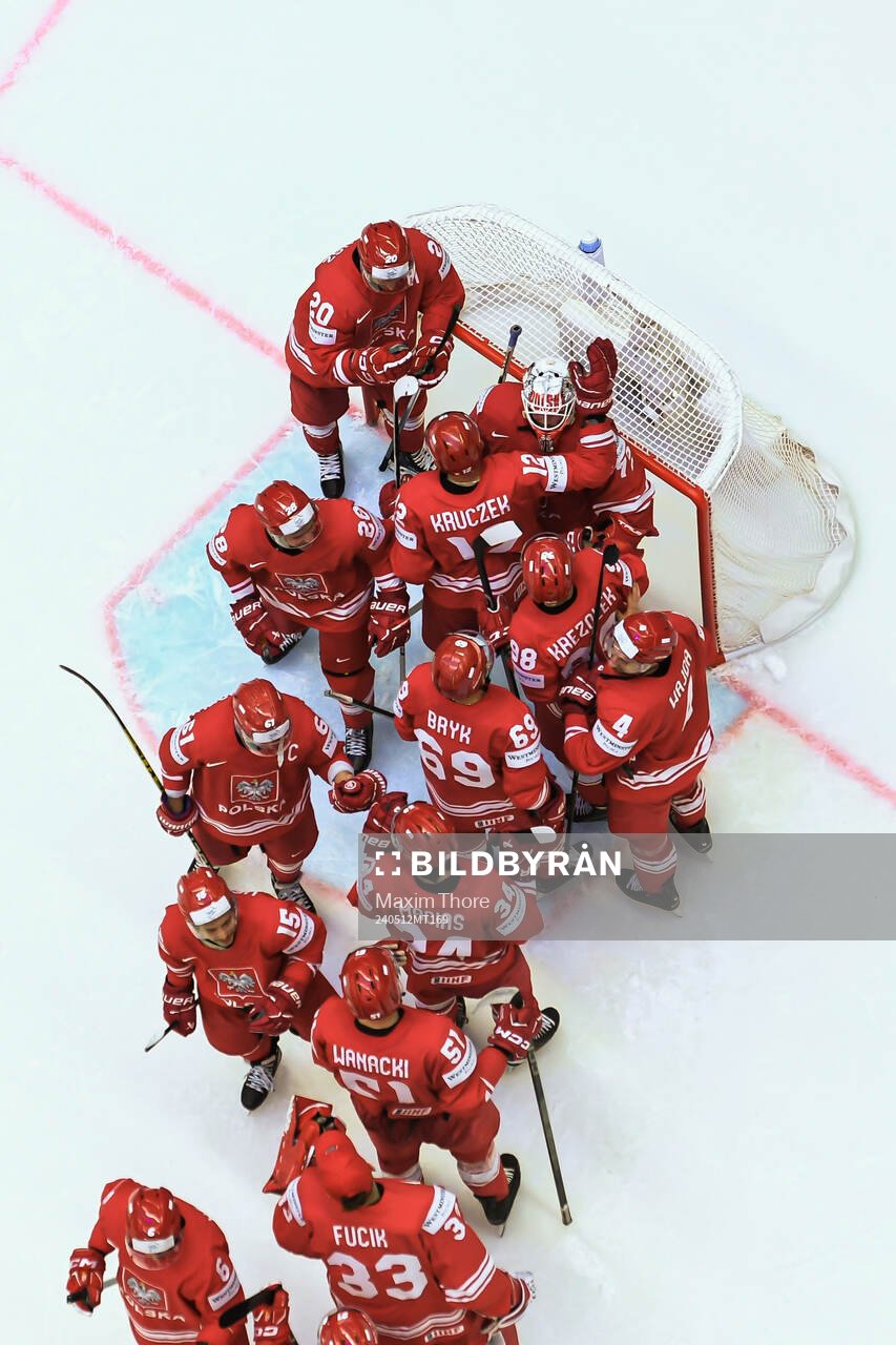 Goaltender David Zabolotny of Poland is embraced by